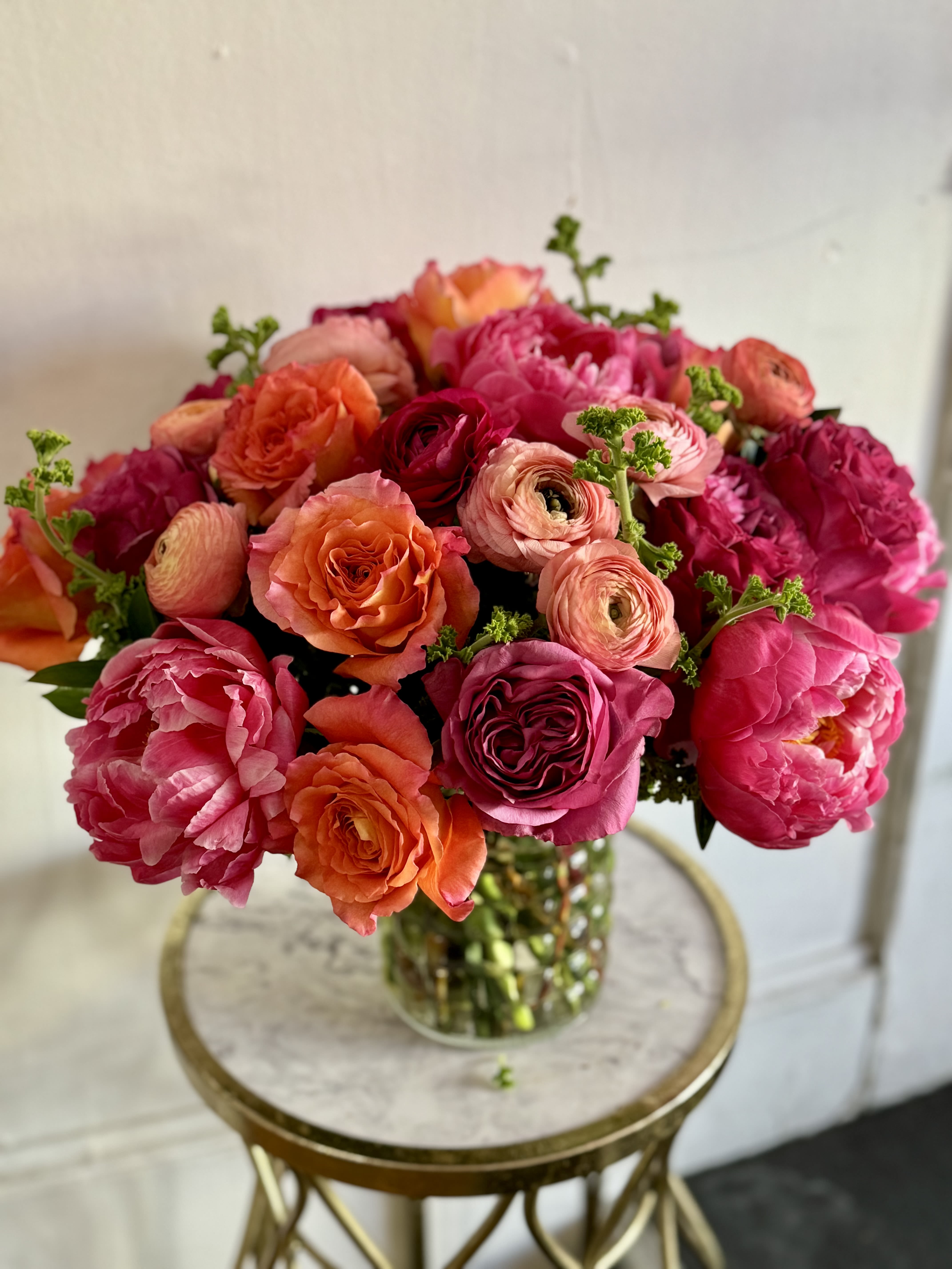 Bouquet of pink, orange, and red flowers in a glass vase