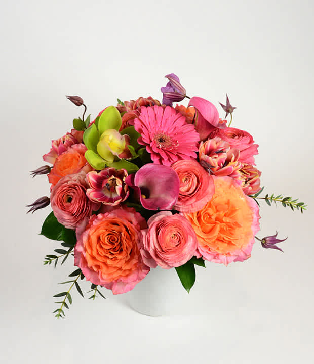 Pink and orange mixed bouquet in a white vase