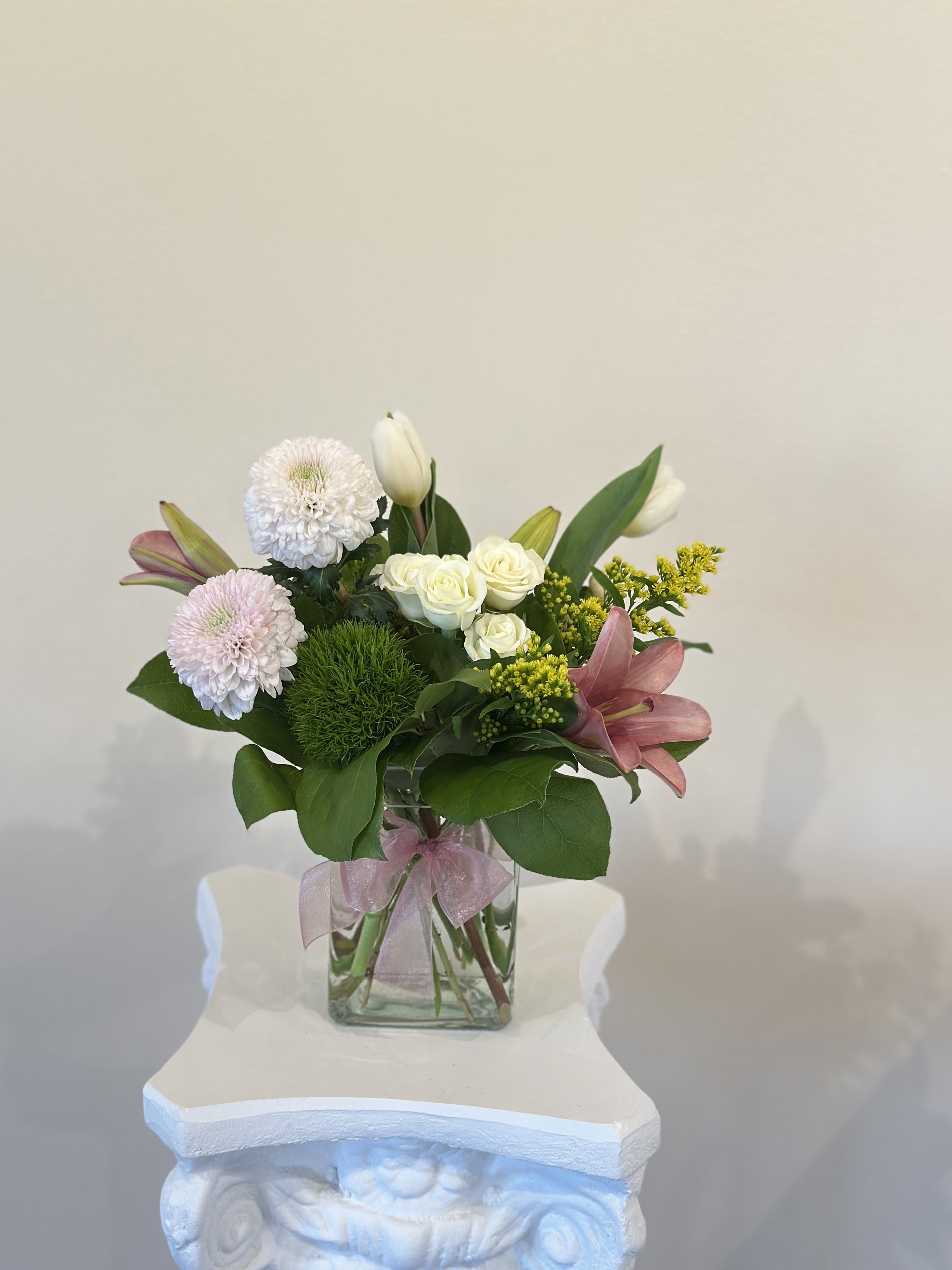 Mixed bouquet in a clear glass vase with pink lilies and white roses