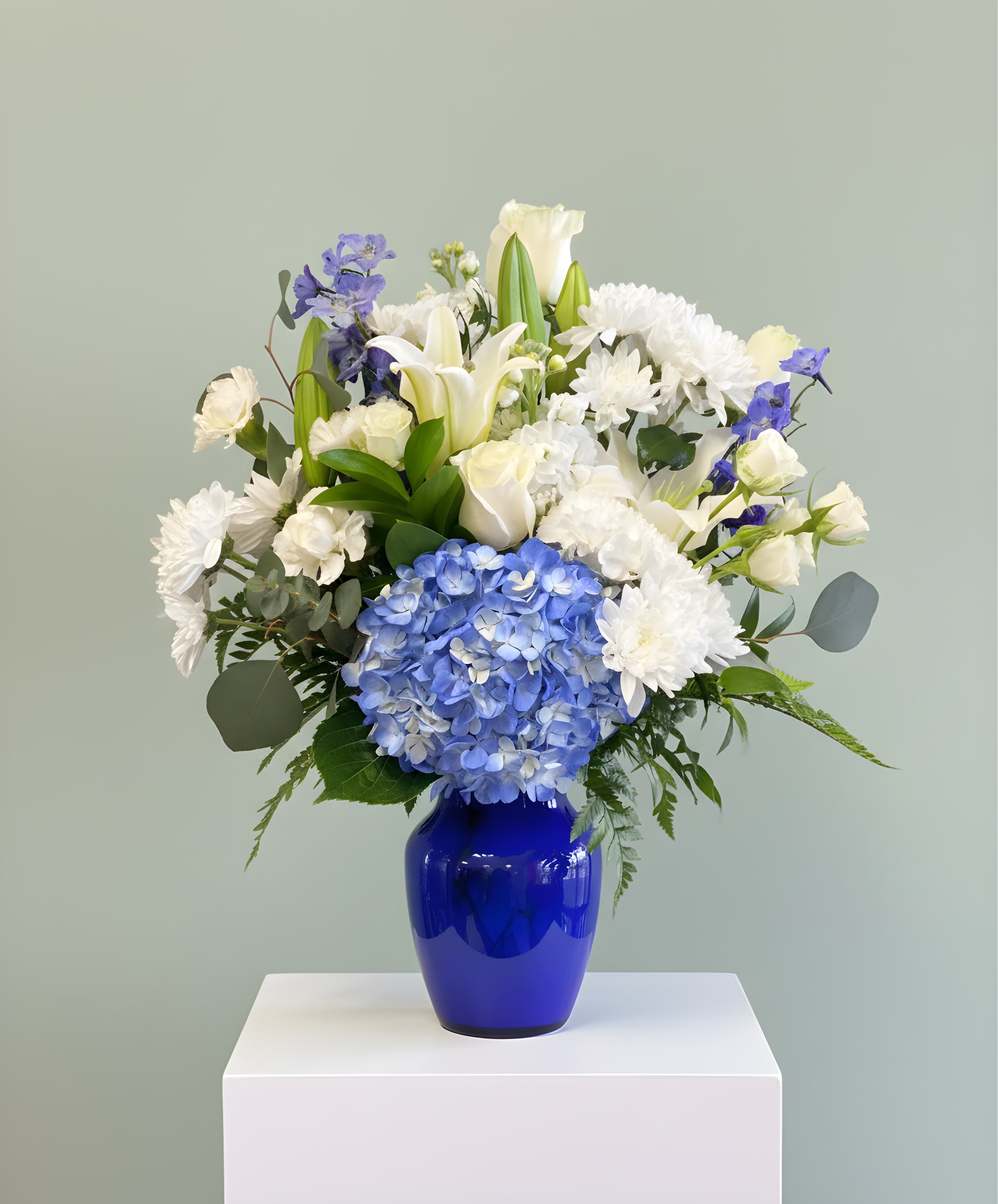Blue and white floral arrangement in a cobalt vase