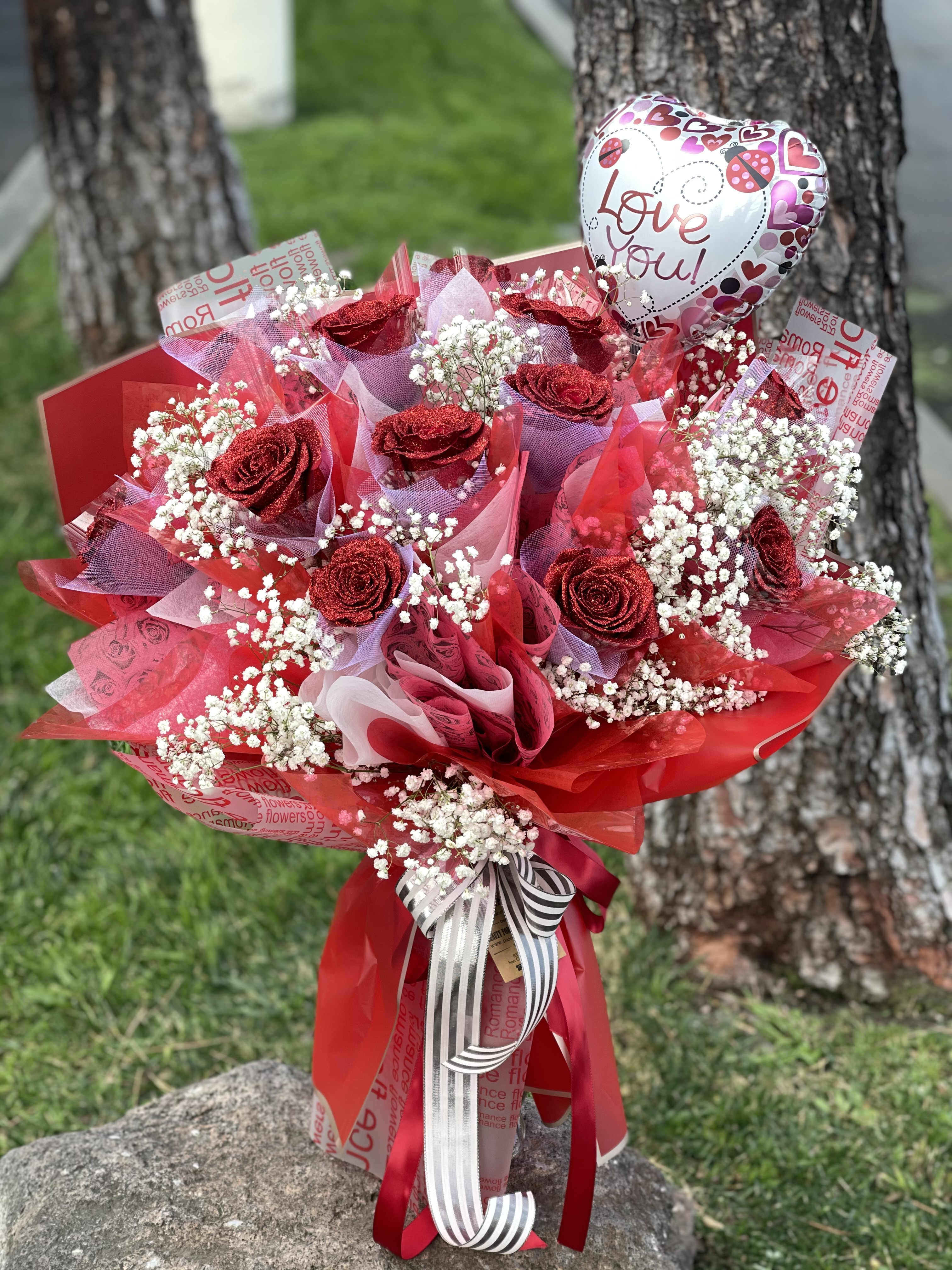 Red rose bouquet with baby’s breath and a heart-shaped "Love you" balloon