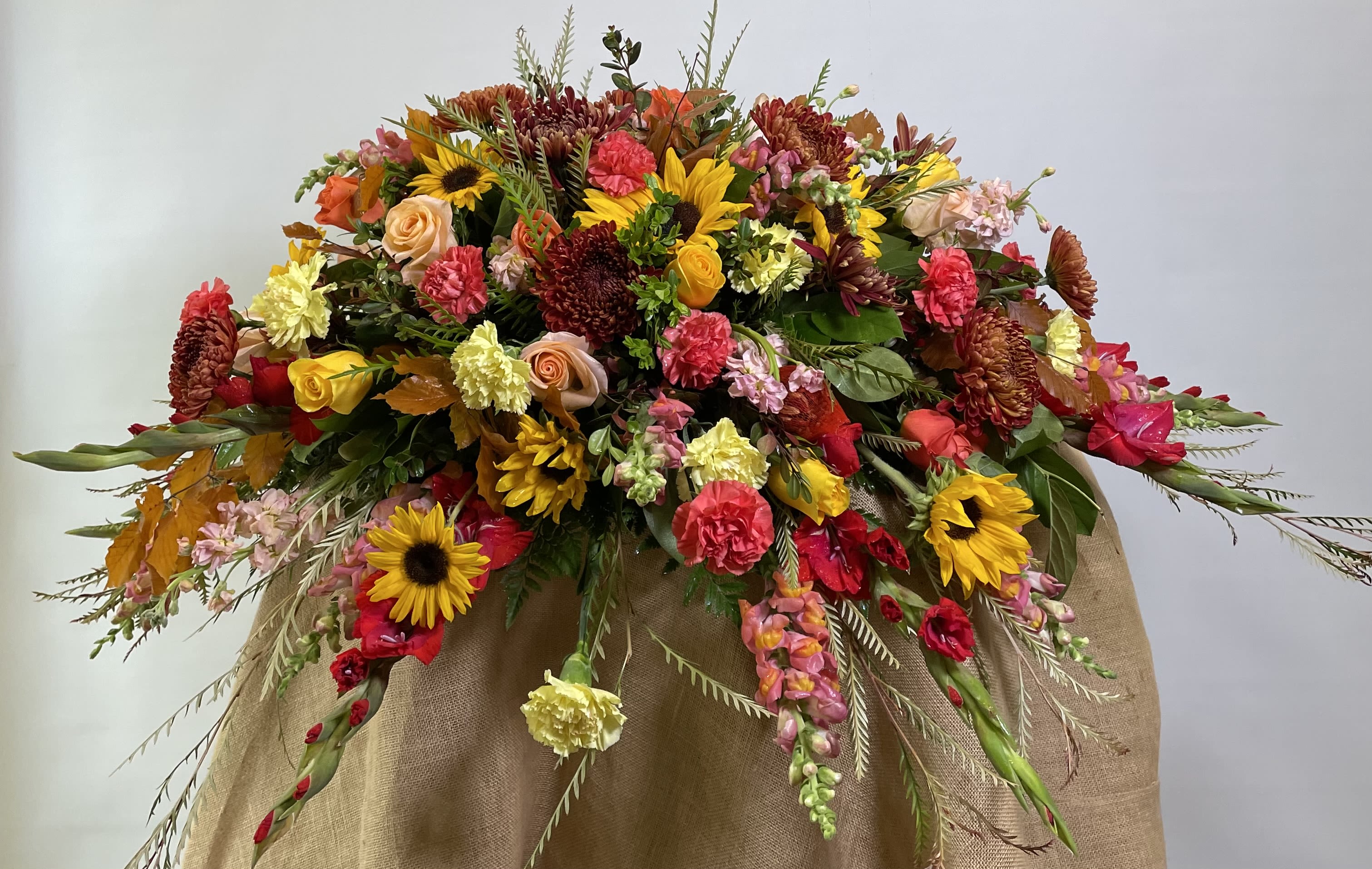 Large mixed floral arrangement with sunflowers, roses, and carnations