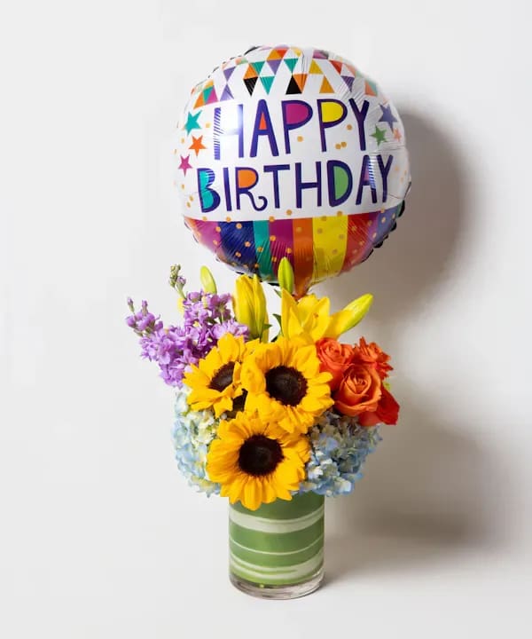 Beautiful, colorful bouquet - What better way to say "Happy Birthday" than with our Birthday Blooms arrangement? This beautiful, colorful bouquet is filled with hydrangea, sunflowers, roses, asiatic lilies, and lisianthus in a tall cylinder glass leaf-lined vase, and comes with a fun birthday mylar balloon to add the finishing touch to your birthday wishes! 