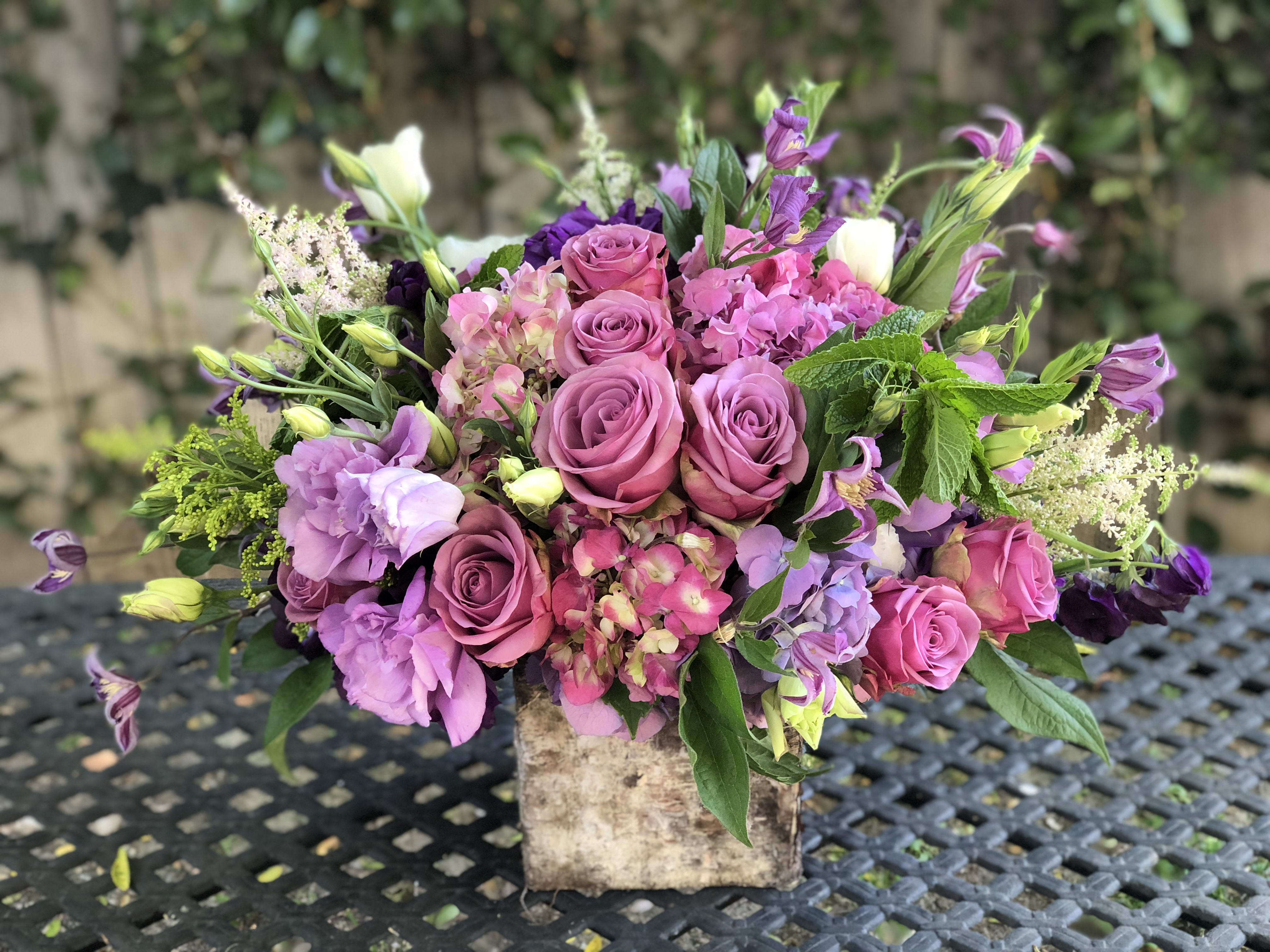 Pink and purple mixed bouquet in a rustic square container