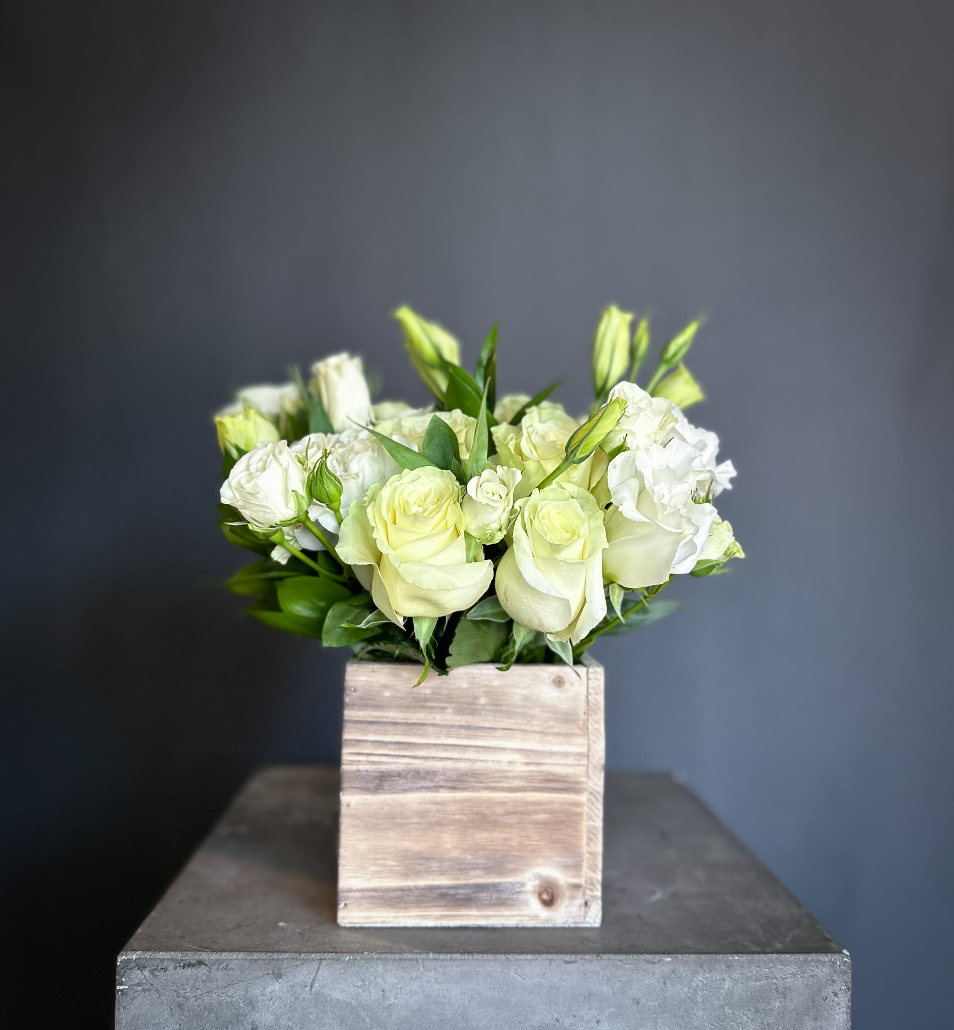 White roses and lisianthus in a wooden box
