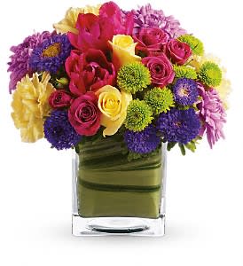 One Fine Day - A chic, stylish twist on classic spring flowers! Creamy yellow roses pop against the bright pastel flowers of this modern arrangement, presented in a glass cube vase that's lined with a tropical aspidistra leaf. A high-fashion pick for the haute Couture set!
