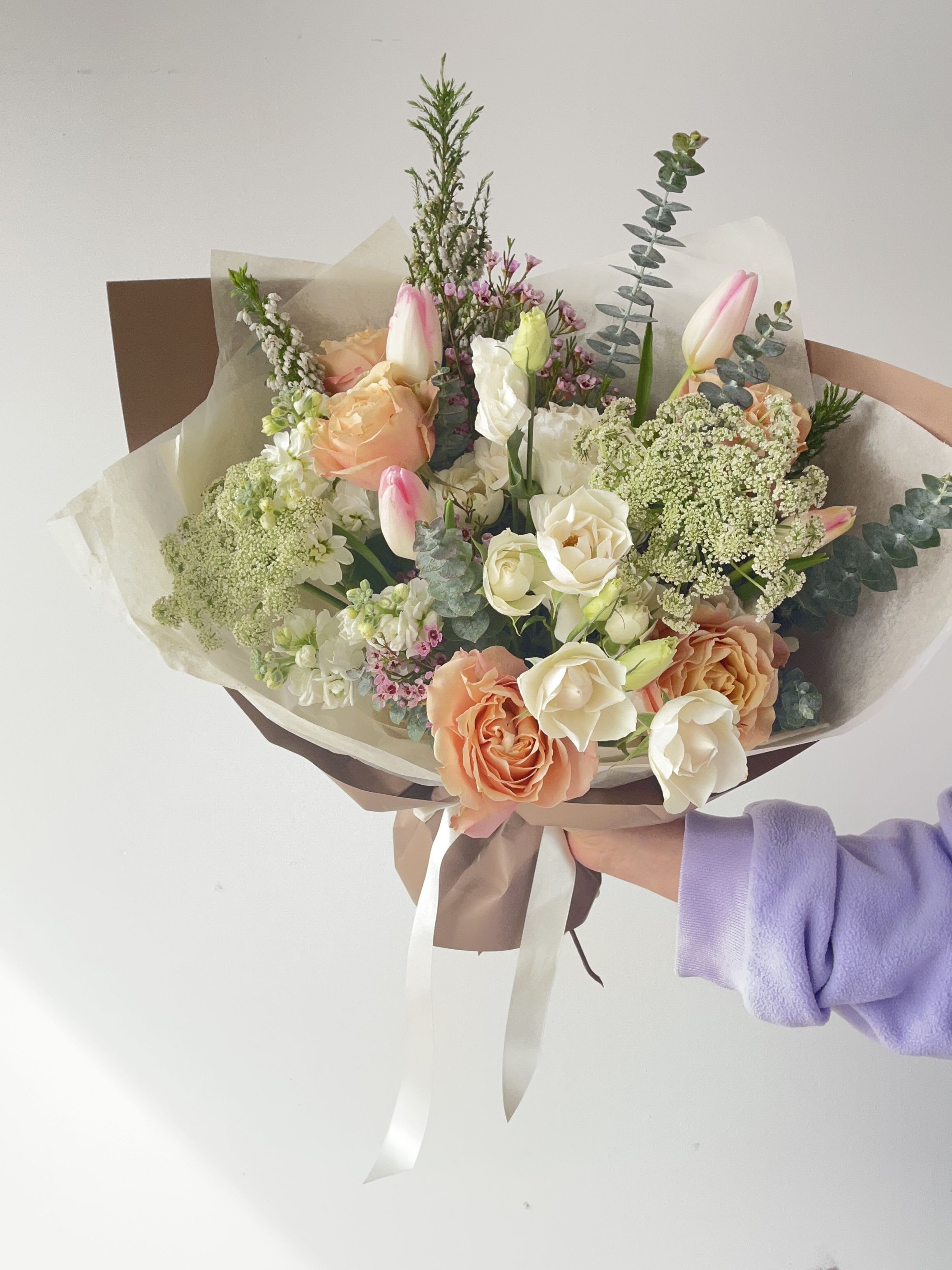 Hand-tied bouquet of peach and white roses with pink tulips