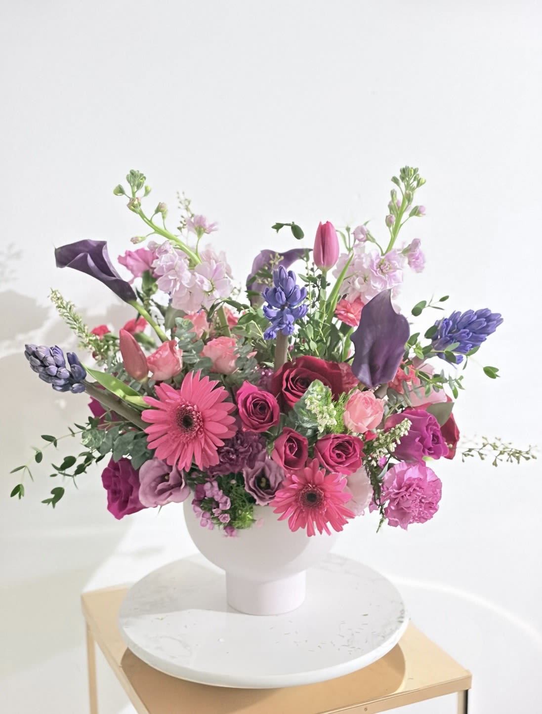 Pink and purple mixed bouquet in a white vase
