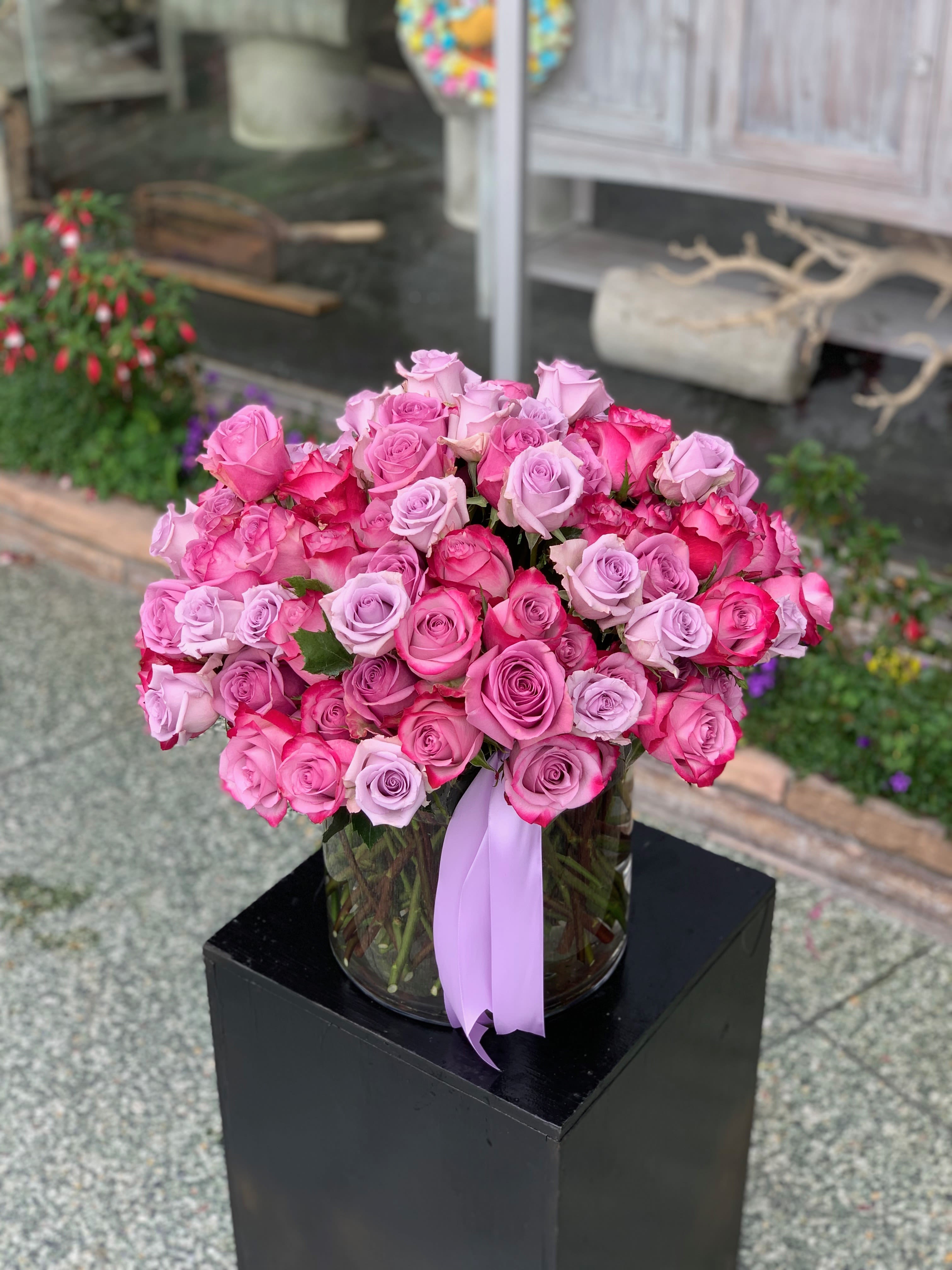 100 Luxury Roses - This arrangement features a variety of imported, premium roses arranged in a large glass vase. Please specify the color of your choice upon ordering.