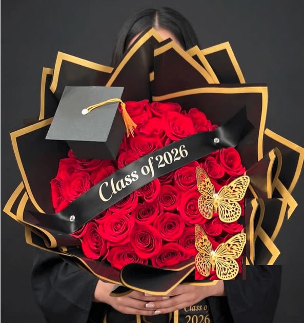 Celebrate Graduation Bouquet Wrapped - A bold, elegant bouquet built to celebrate her biggest milestone. premium 24 red roses wrapped in black paper with gold trim, finished with a graduation cap topper, a gold butterfly accent, and a banner that reads "Class of 2026.