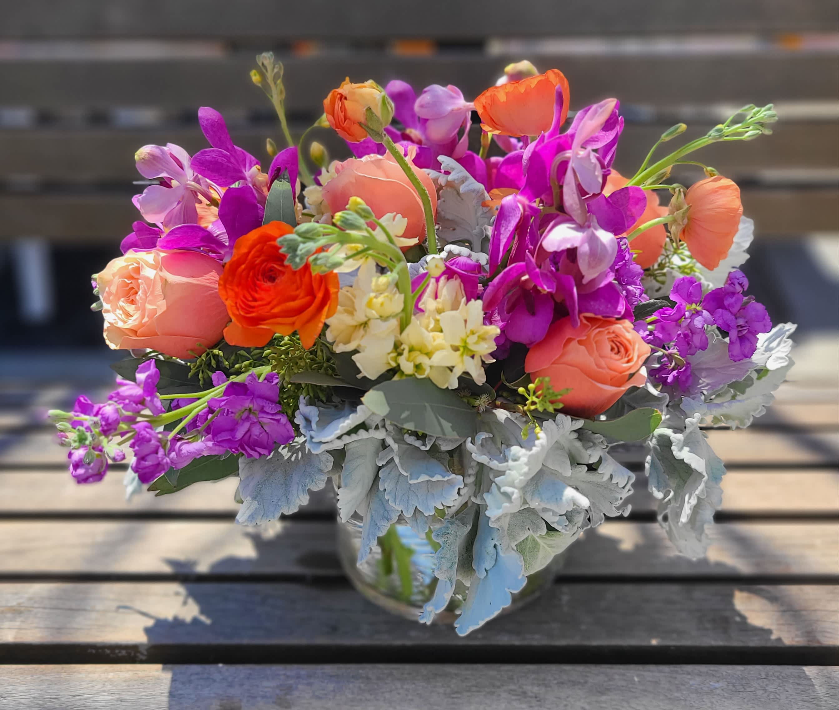 Peachy Keen - This arrangement is a new design using peaches, oranges and purples. The foliage adds a delicate touch with grey undertones.