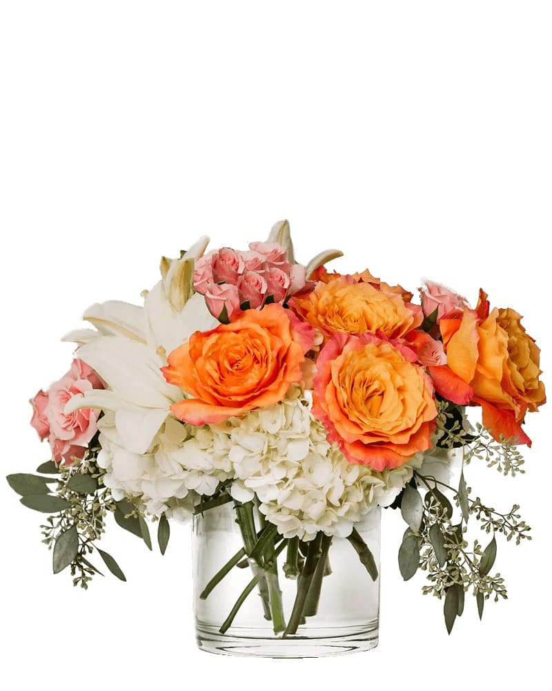 Bouquet of orange and pink roses with white lilies in a glass vase