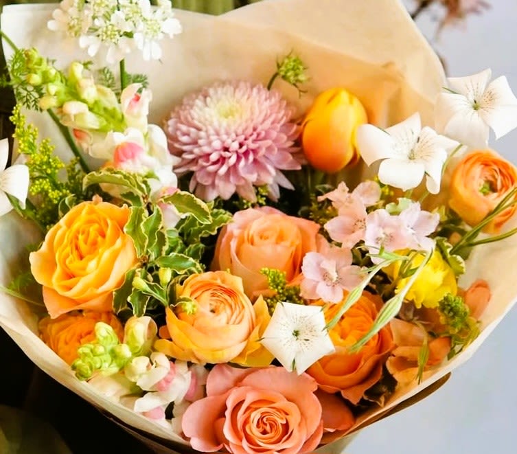 Bouquet of orange and pink roses with white flowers and a pink chrysanthemum