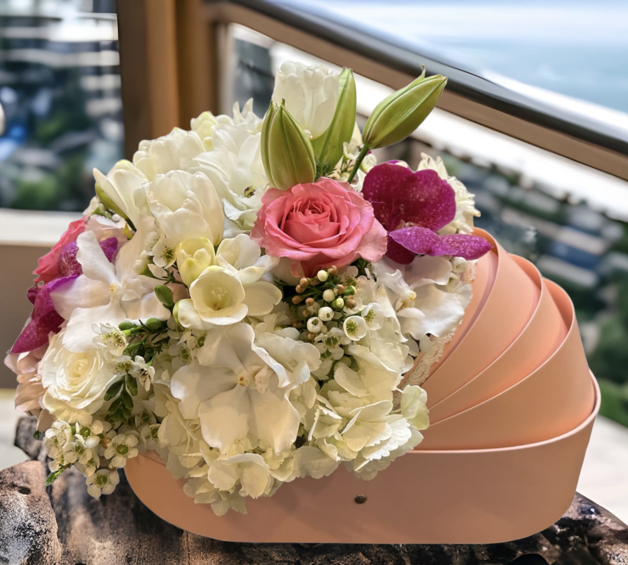 Pink and white bouquet in a peach hatbox with lilies and roses