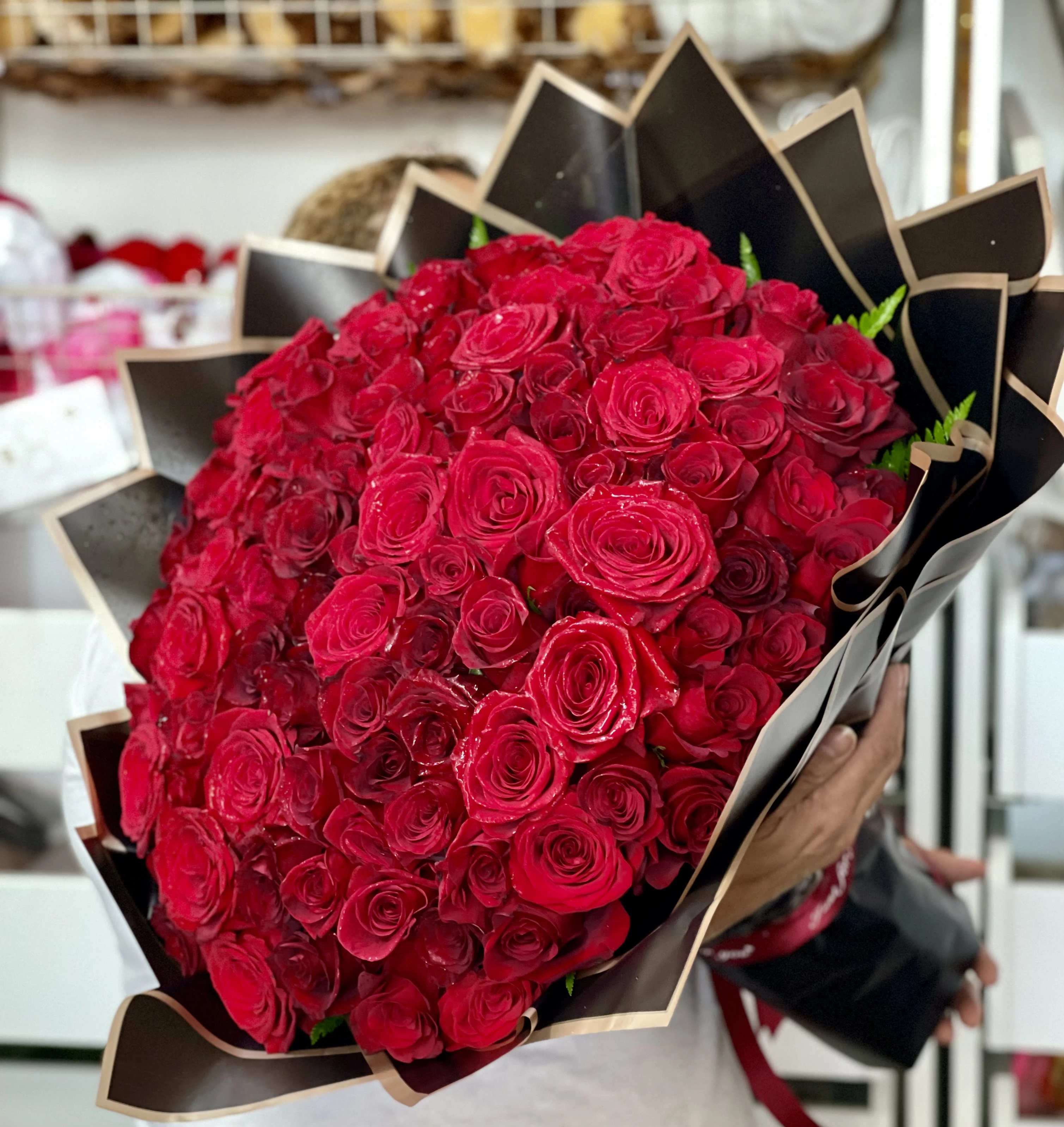 Large bouquet of red roses wrapped in black paper