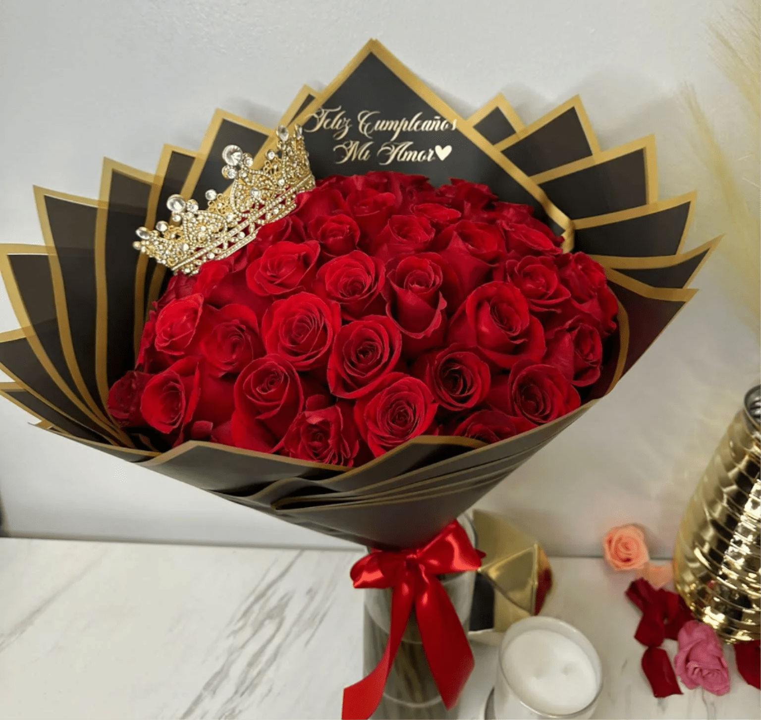 Bouquet of red roses with a jeweled crown and black-and-gold wrapping