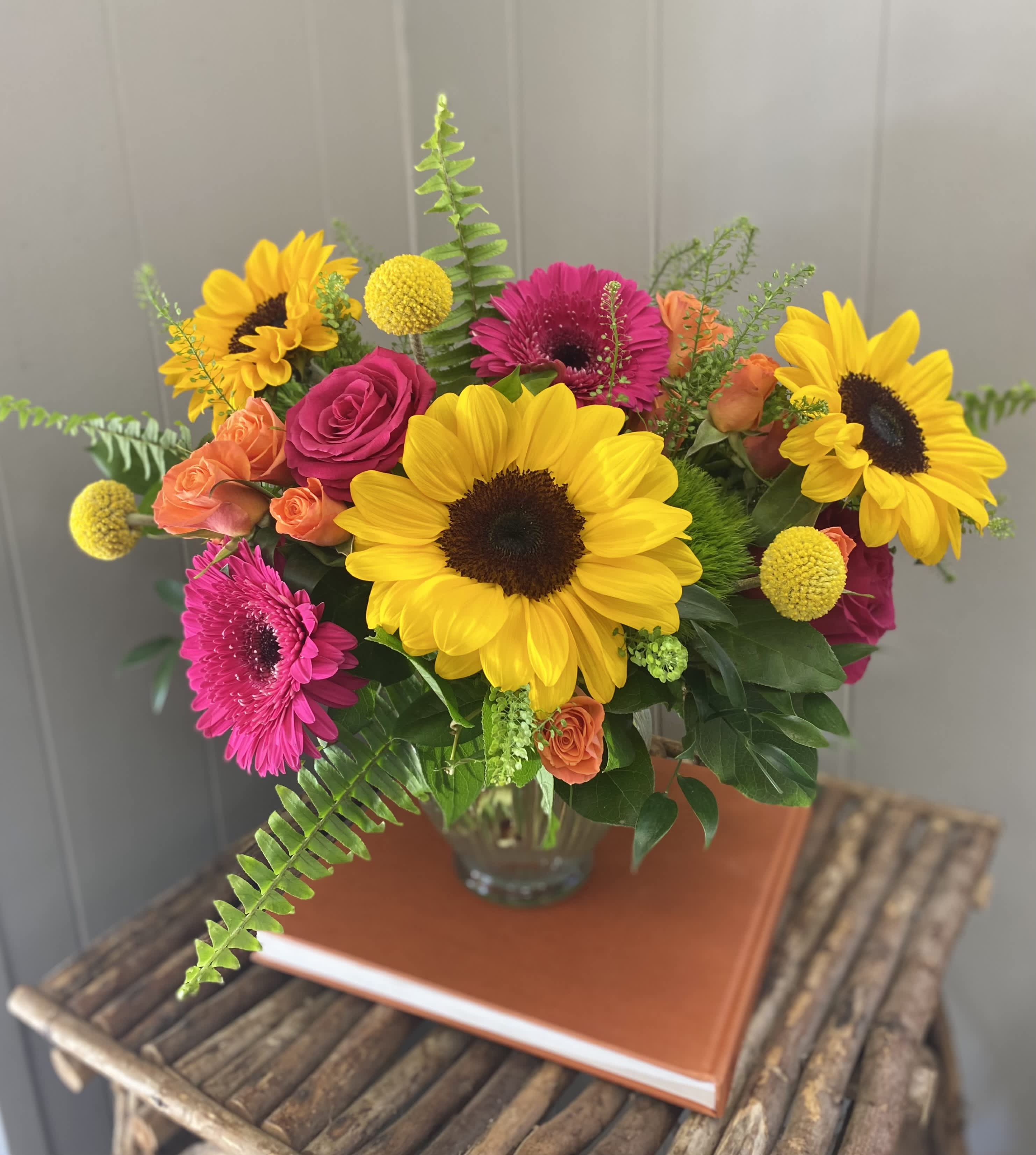 Sunshine - This bright and cherry arrangement is sure to make anyone smile! Including sunflowers, roses, gerbera daisies, billy balls, and more. 