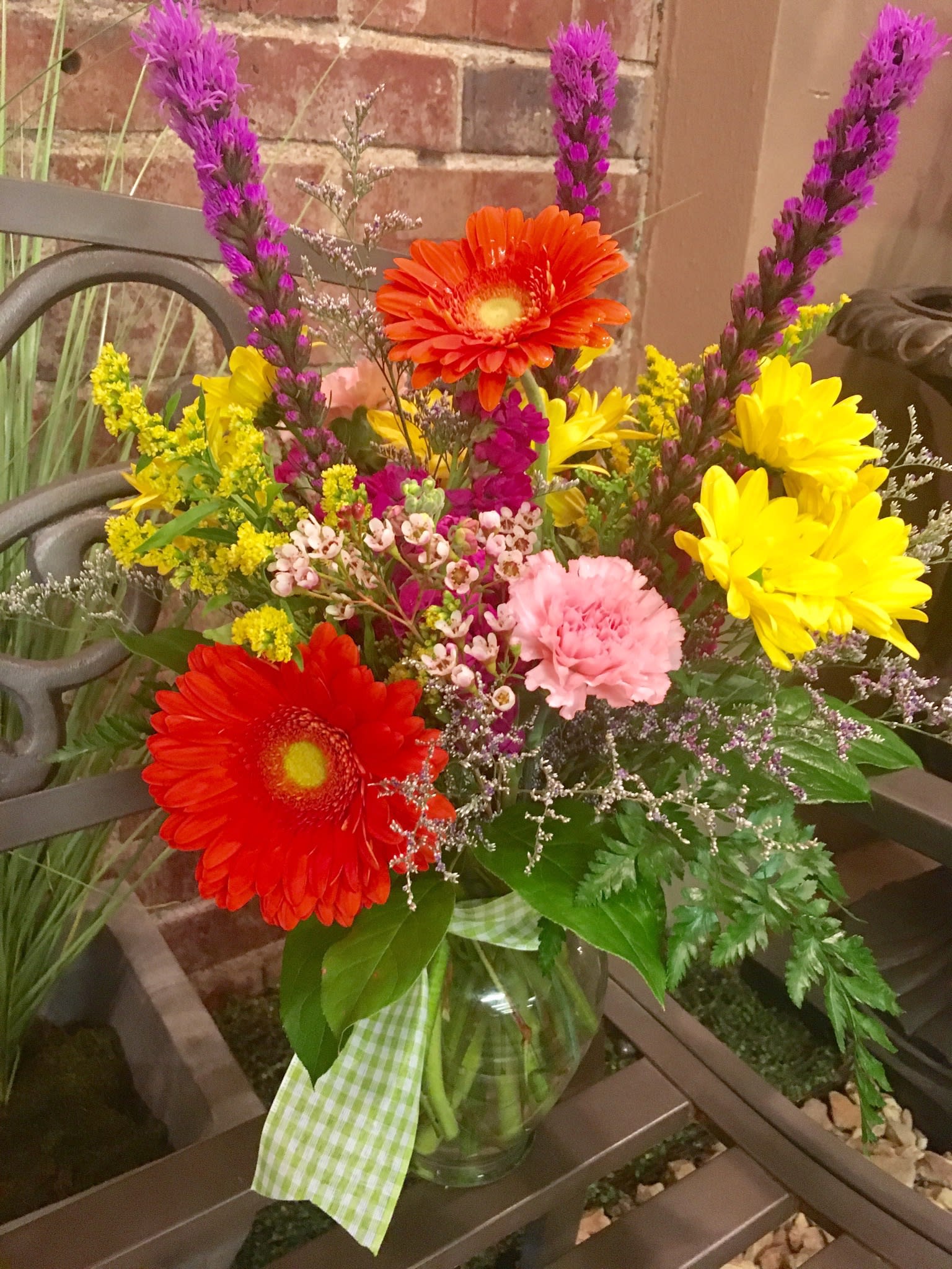 Colorful mixed bouquet in a glass vase with gerbera daisies and carnations