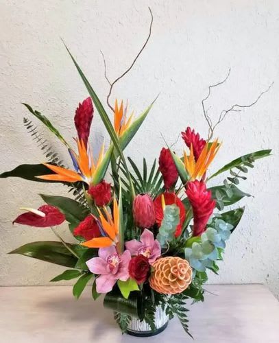 Tropical flower arrangement with red and orange blooms in a vase