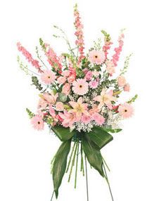 Tall standing spray of pink flowers with large green leaves on a metal easel