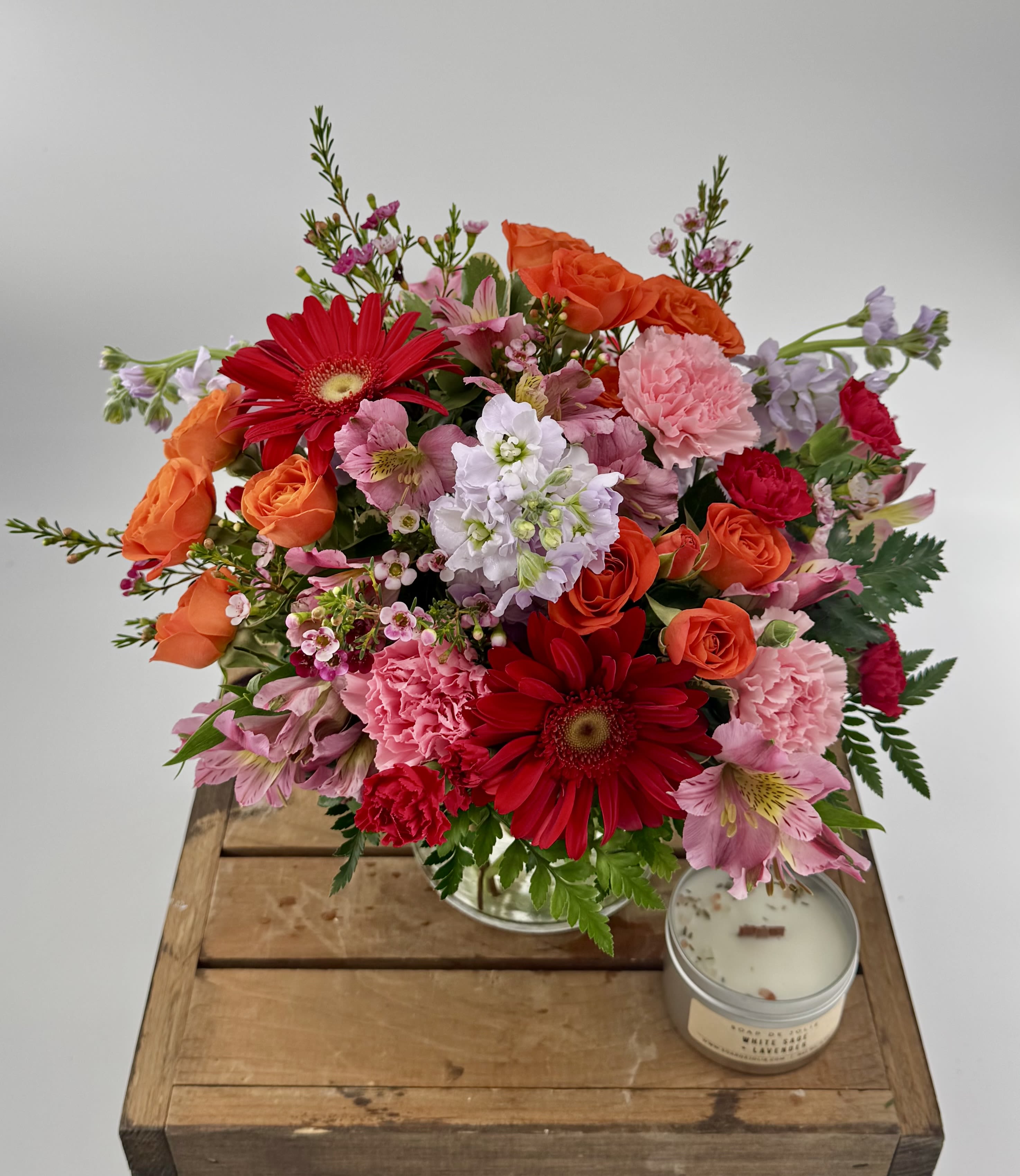 Festive Fiesta  (DL) - Get ready to add a burst of vibrant energy to any occasion with our "Fiesta" floral arrangement. This arrangement is an exciting blend of bright and bold colors, featuring hot pink roses, carnations, orange gerbera daisies, and spray roses.  