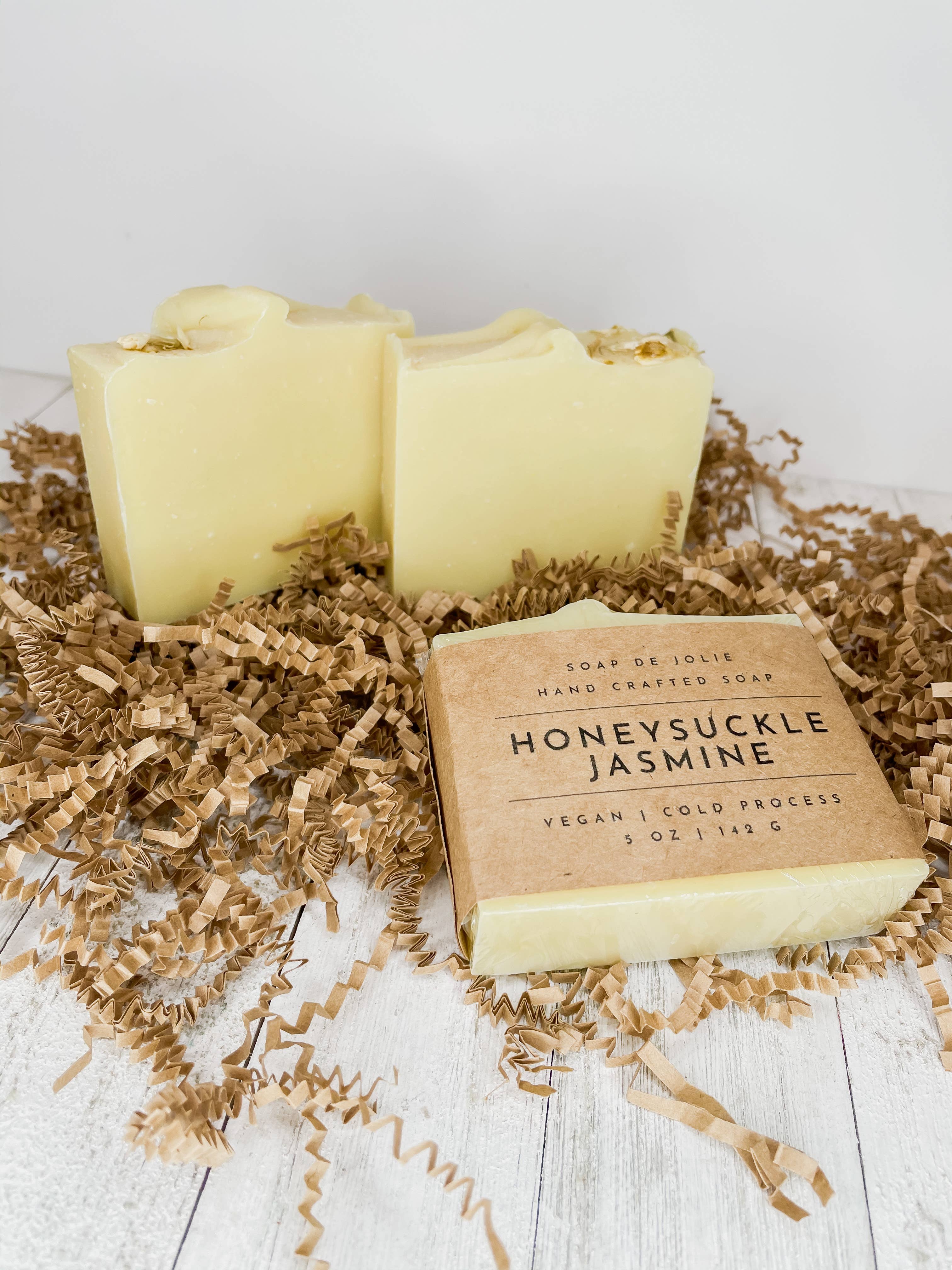 Honeysuckle Jasmine Cold Process Soap (BB) - This all natural, cold process soap bar has a soft, dreamy scent that opens with top notes of lemon and ginger before giving way to a heart of jasmine and honeysuckle. Hints of violet, powder, and amyris mingle with wood notes in the base of this well-rounded floral fragrance. Ingredients: Kayolin Clay, Sweet Almond Oil, Olive Oil, Caster Oil, Coconut Oil, Avocado Oil, Sodium Hydroxide, Jasmine Flowers, Mica and FO