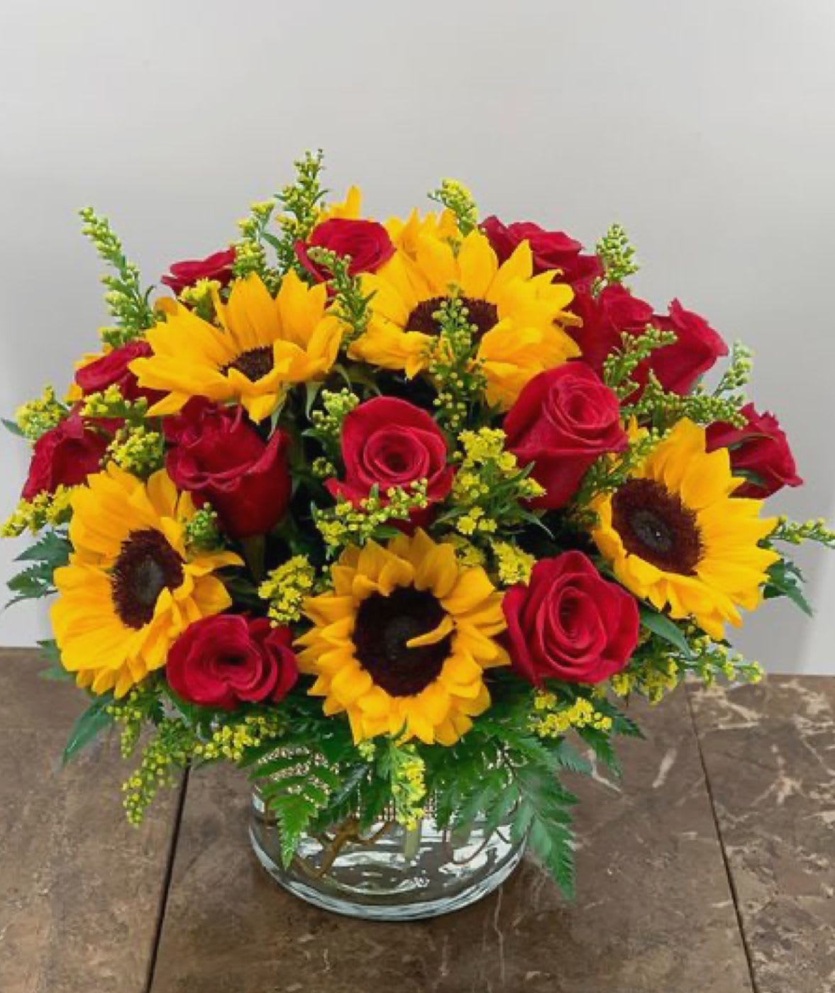 Sun-kissed love - A radiant arrangement of golden sunflowers and passionate red roses , symbolizing warmth , happiness and deep affection. Perfect for brightening any moments.