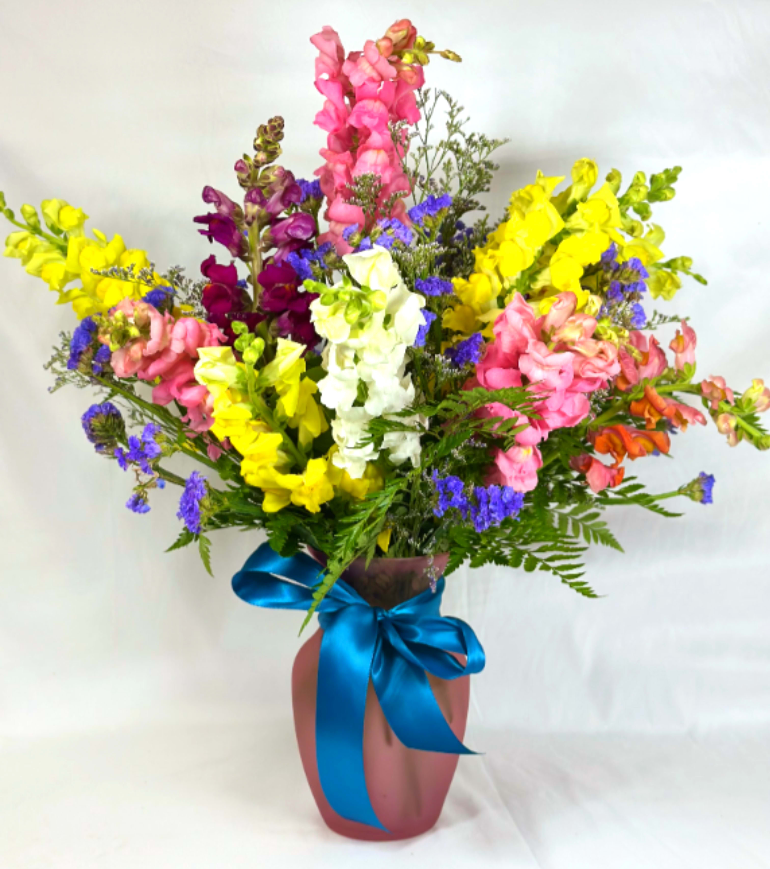 Make it Snappy! - What a perfect Mother's Day arrangement! Tall beautiful Snapdragons in a variety of colors in a pretty pink vase with a satin bow and a special shout out to Mom! This Leary's Flowers exclusive design will be the gift that makes her smile. We use only the freshest blooms in our work so the colors of the flower will be chosen with that in mind