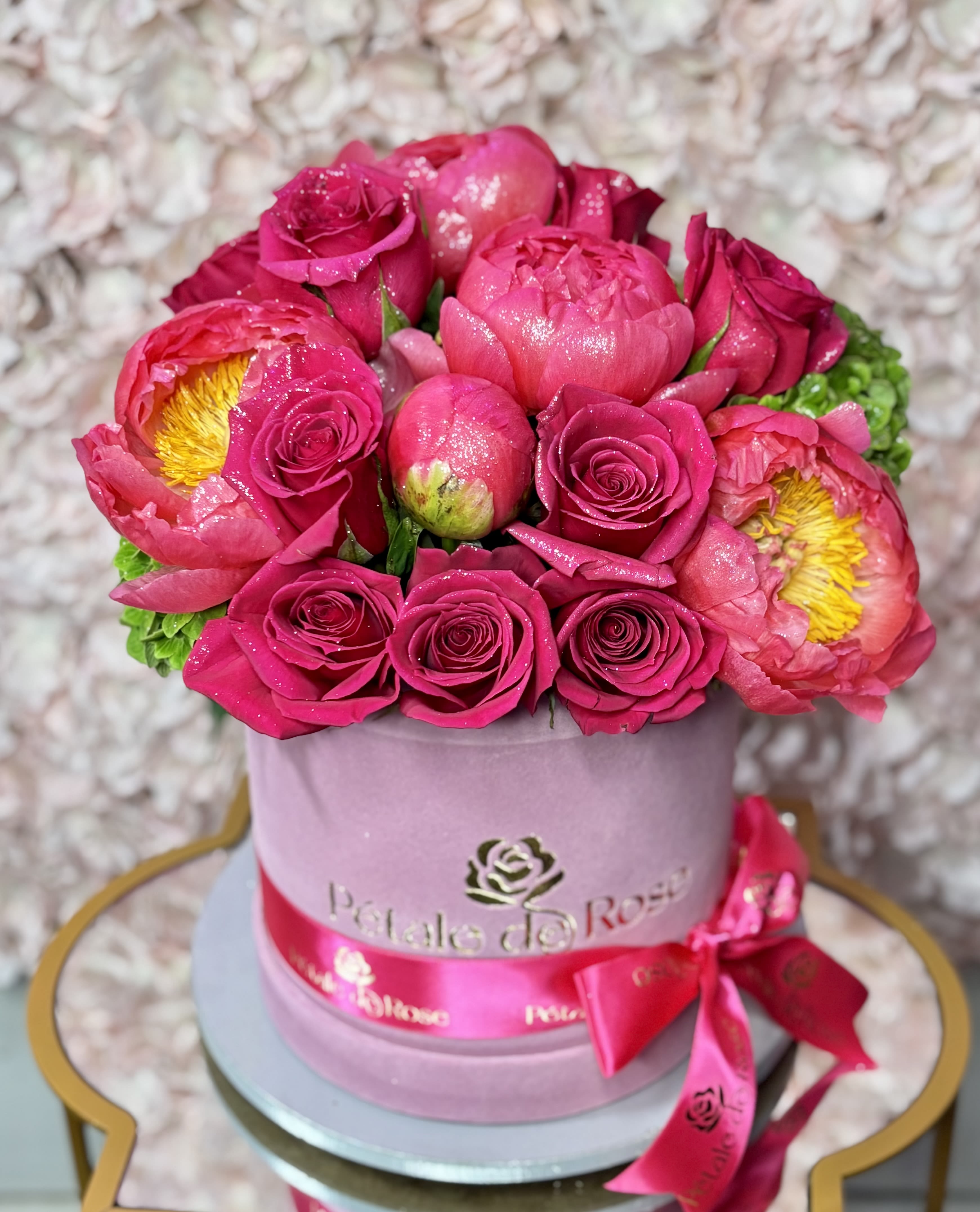 Peony Bloom - A luxurious floral box designed to celebrate Mom in the most elegant way  Featuring fresh roses, premium coral peonies, and fresh seasonal textures arranged in our signature flower box.  A romantic and sophisticated design full of beauty, fragrance, and charm   • Fresh premium flowers • Designed in our signature box • Limited seasonal peonies available  (Please note: Flower substitutions and shades may vary based on seasonal and market availability. Our designers will always maintain the overall color palette, freshness, style, and luxurious feel of the arrangement shown.) 