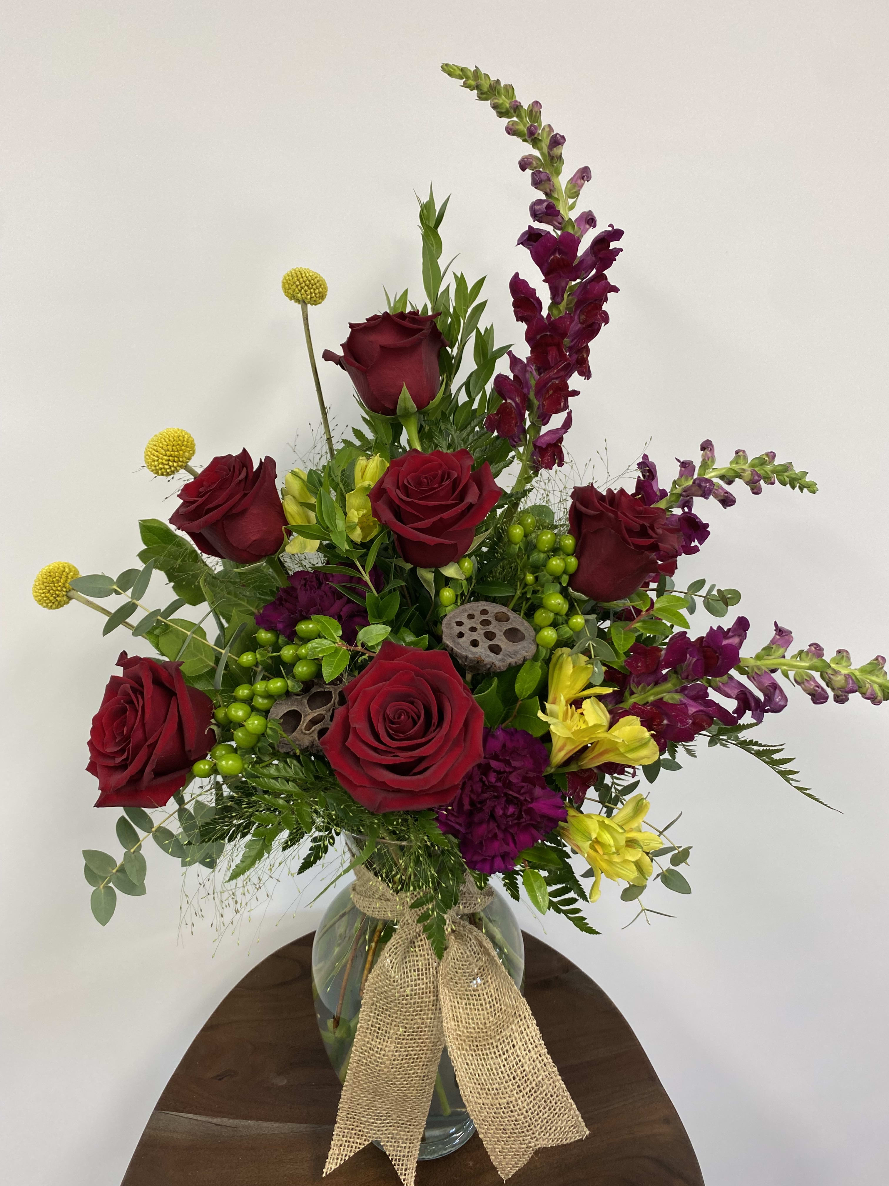 Bold Beauty - Rich red roses mixed with fall colors make this the perfect arrangement to wow anyone. 28” tall x 20” wide. It’s a stunner!