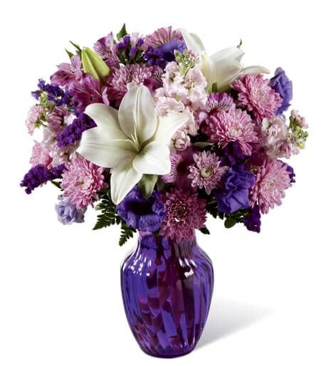 Purple and pink mixed bouquet with white lilies in a purple vase