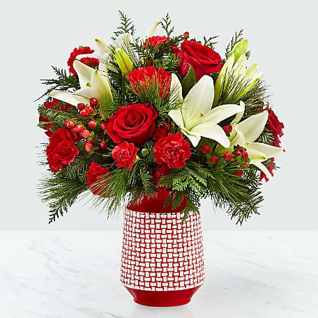 Sweet Joy Bouquet - Hues of red are contrasted with bursts of white to make a bouquet that is sweet and beautiful. With classic red roses and red carnations, the bold white Asiatic lilies give the Sweet Joy Bouquet a refined look that will leave the recipient with a smile on their face. The red ceramic vase they arrive in boasts a raised white woven pattern. 