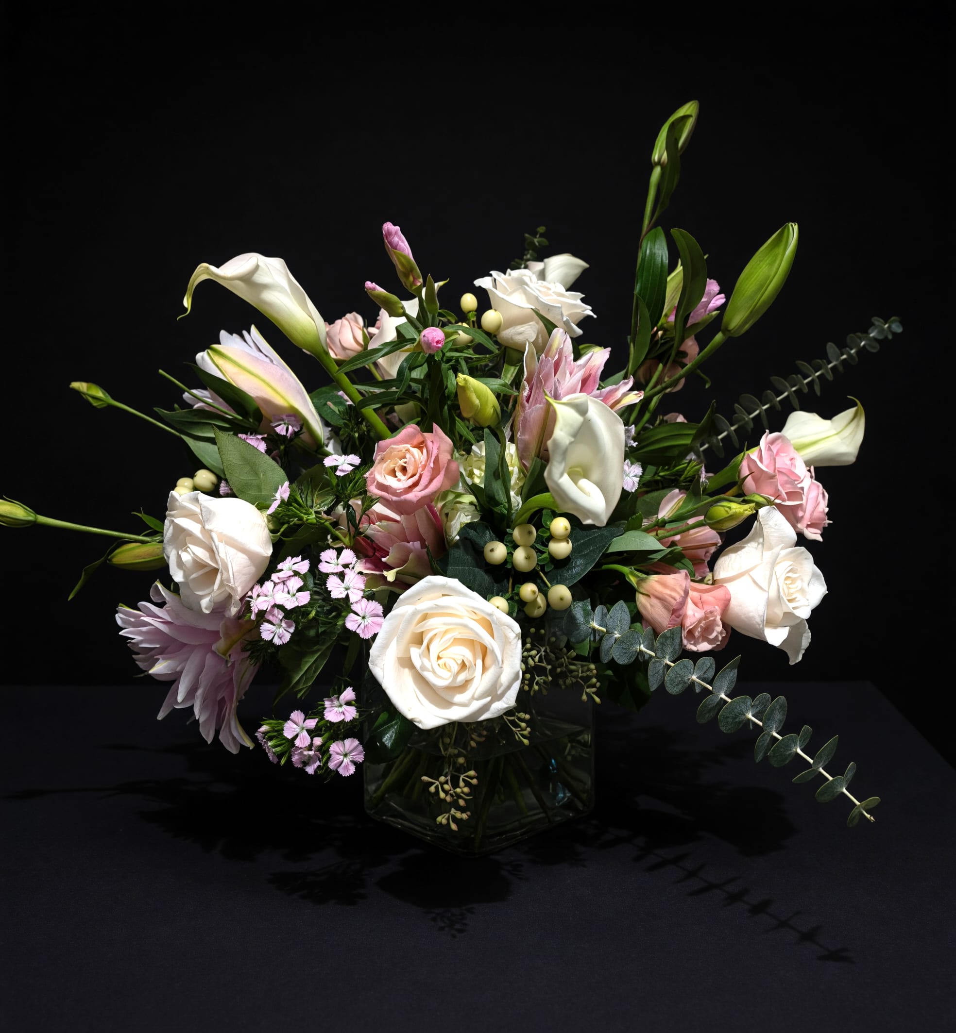 Marseille - Delicate mixture of whites and soft pastels accented with a variety of leafed foliages. Presented in a clear glass container with exposed stems