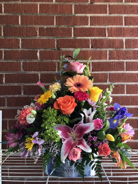 Colorful mixed flower arrangement in a metal container