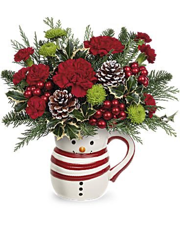Send A Hug Sweet Frosty Bouquet  - Whether filled with festive flowers for Christmas or hot cocoa in the New Year, this smiling sweet frosty snowman mug vase spreads whimsical winter cheer. Order these Christmas flowers and put a smile on your loved one's face.  Red carnations, miniature red carnations and green button spray chrysanthemums are arranged with noble fir, cedar and variegated holly. This Christmas bouquet is delivered in a Sweet Frosty Mug.