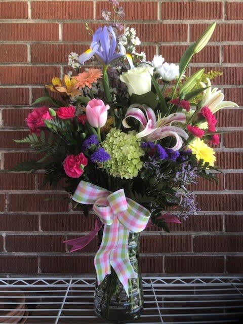 SPRING IS IN THE AIR - A BEAUTIFUL BOUQUET OF A VARIETY OF BRIGHT SPRING FLOWERS IN A VASE.  