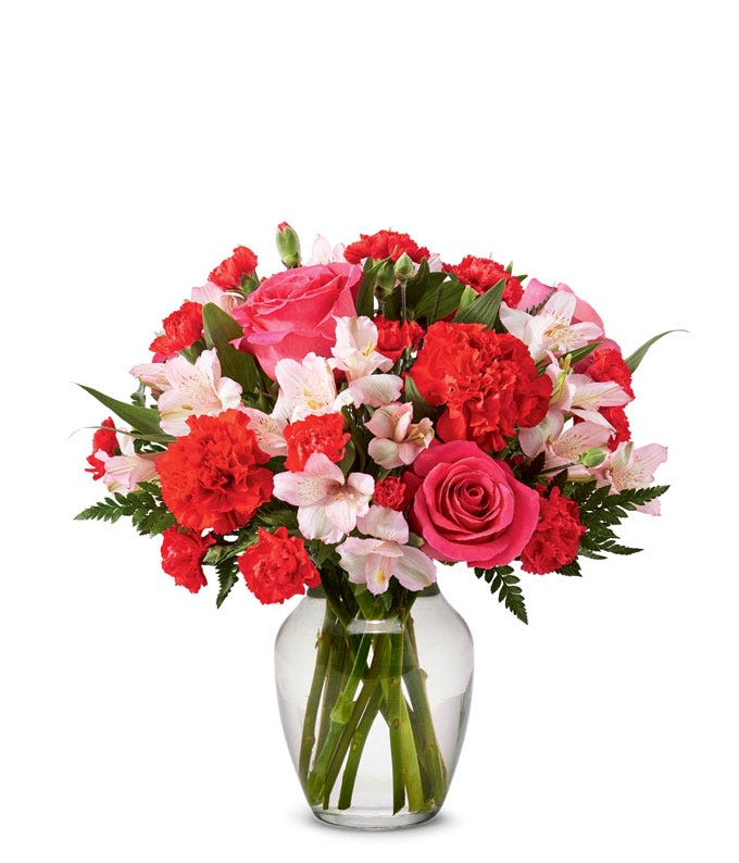 Pink and red flower bouquet in a clear glass vase