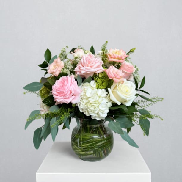 Quality Time Bouquet - EVERYDAY COLLECTION | LOCAL DELIVERY ONLY  A soft, garden-style arrangement designed in a stylish Rio vase with bear grass accents, it features white hydrangea, mojito hydrangea, short stem roses, garden roses, lisianthus, Queen Anne’s lace, pennycress, and mixed greenery for a fluffy, elegant, heartfelt feel that encourages presence and connection.