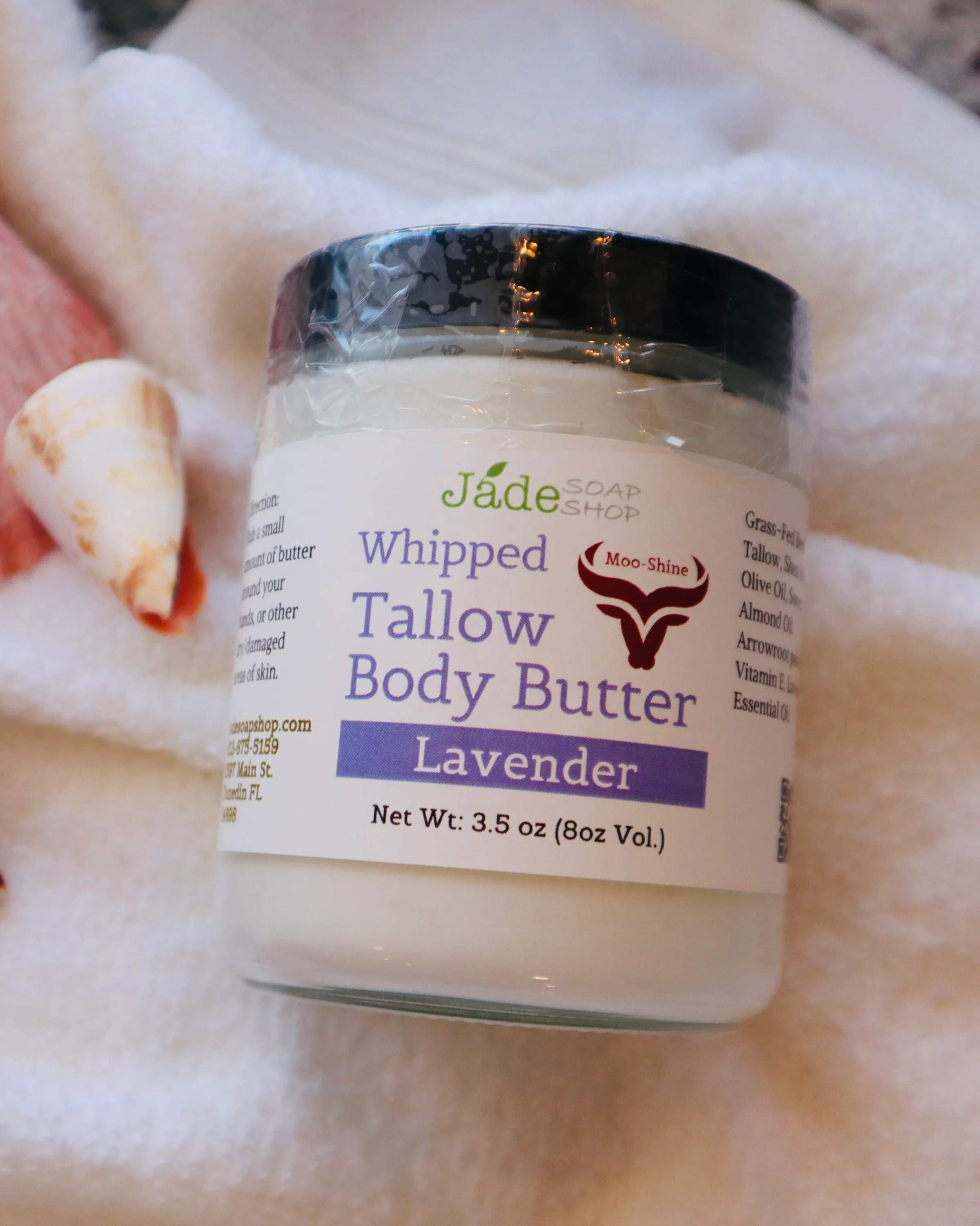 Moo-Shine Whipped Tallow Body Butter - Lavender - Moo-Shine Whipped Tallow Body Butter - LAVENDER (Net Wt. 3.5 oz.)  Whipped body butter is rich in oils and butters like shea butter, cocoa butter, which provide deep hydration to the skin. It helps lock in moisture, keeping the skin soft, supple, and hydrated for longer periods. It is ideal for Dry Skin: It's especially beneficial for dry or rough skin, as it provides intense nourishment and can help restore the skin's natural moisture balance. HANDMADE from our local partner's at JADE SOAP SOAP (in Pinellas County, FL)  Ingredients: Organic Grass fed Beef Tallow. Shea Butter, Sweet Almond Oil. Arrowroot powder. Vitamin E Oil. Lavender Essential Oil.  Key Ingredients: Beef tallow, derived from rendered beef fat, offers several potential benefits for skin health and skincare.   Beef tallow in whipped body butter provides excellent skincare benefits. It mimics human skin oils, offering vitamins A, D, E, and K for hydration. Its anti-inflammatory properties soothe the skin, and it absorbs well without greasiness. Sourced from grass-fed cows, it's also a sustainable choice, making your body butter both luxurious and eco-friendly. Direction: Rub a small amount of butter around your hands, or other dry/damaged areas of skin. 