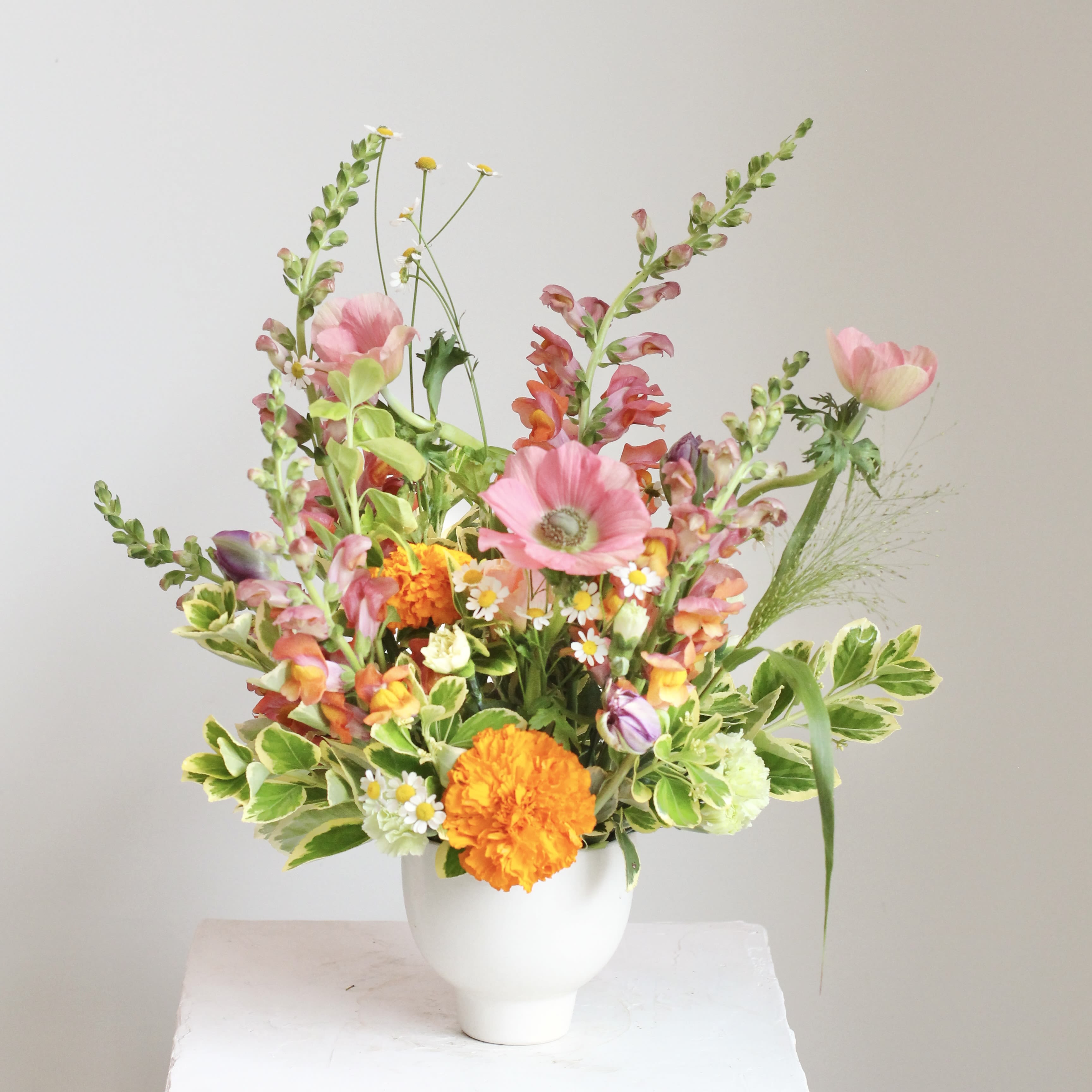 The Golden - Celebrate the ever changing beauty of our beloved hometown with "The Golden", an accent table arrangement designed to brighten your space! This rotating selection of seasonal flowers features stunning blooms in shades of gold, pink, orange, and yellow, bringing warmth and joy to any room or occasion.  Delivery Policy: At Middlemist, we aim to make every delivery seamless and delightful. It is the sender’s responsibility to ensure the recipient is available to accept delivery between 3–5pm on the scheduled date and that the delivery address is accurate. We will send a text notification to the recipient on the day of delivery. If no one is available to receive the order, it will be returned to the shop and may be picked up or redelivered for an additional delivery fee. If a recipient requests the order be left unattended, we cannot guarantee the condition of the flowers or plants, and no refunds will be issued once an order is left outside.