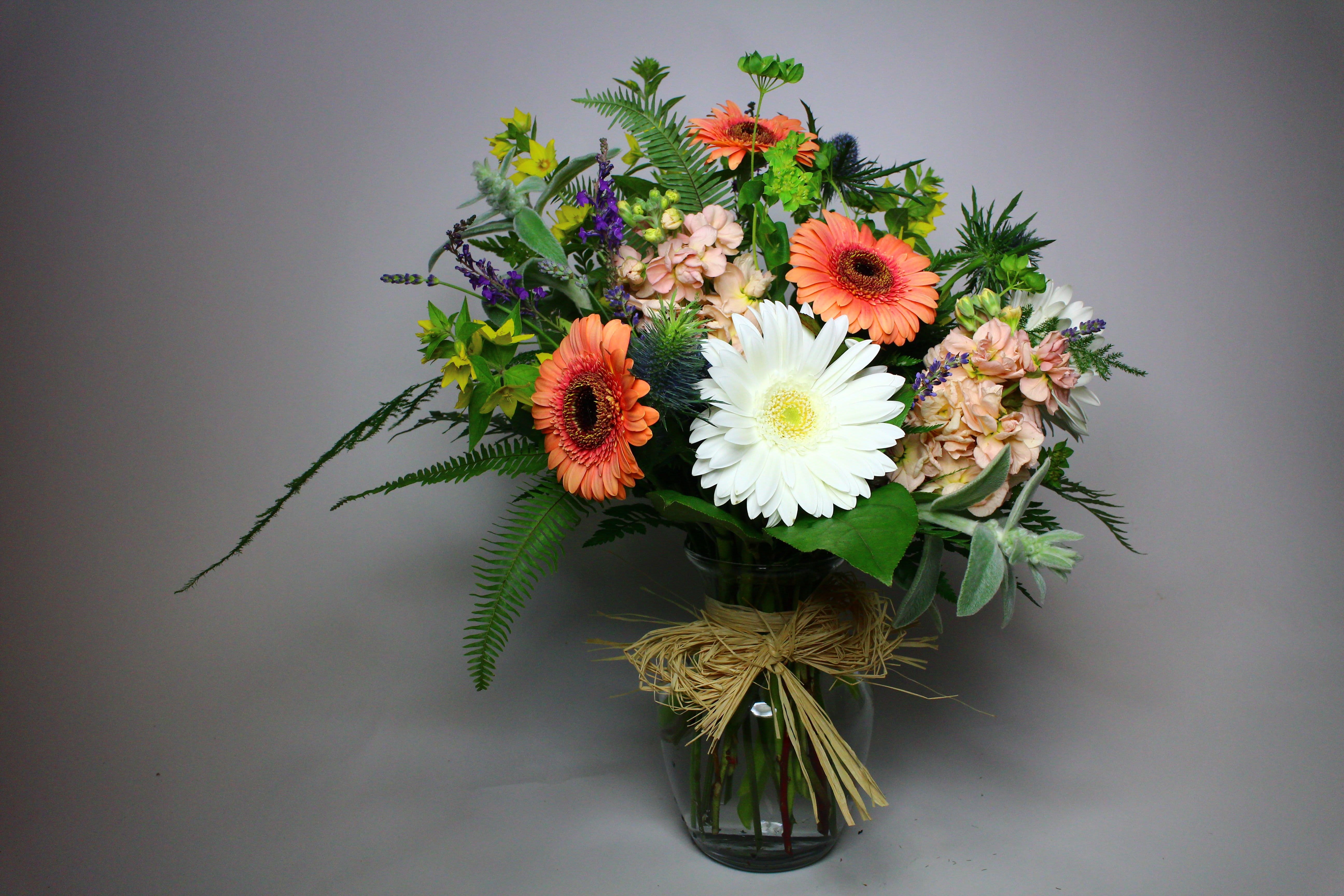 Bouquet of gerbera daisies and mixed flowers in a glass vase