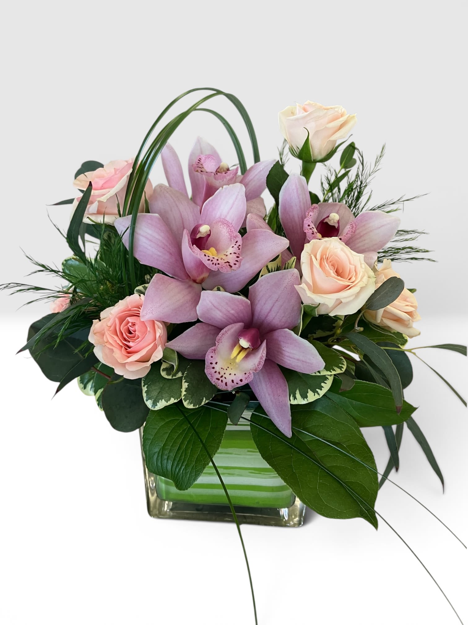 Sweet Blooms Bouquet - This simple and sweet bouquet has big impact on feeling happiness and joy. Send some happiness and joy with mini pink cymbidium orchid blooms and spray roses, accented by textured greenery designed in a square vase. Standard 10x10", want to add more blooms? Increase to Deluxe 11x11" or Premium 12x12"
