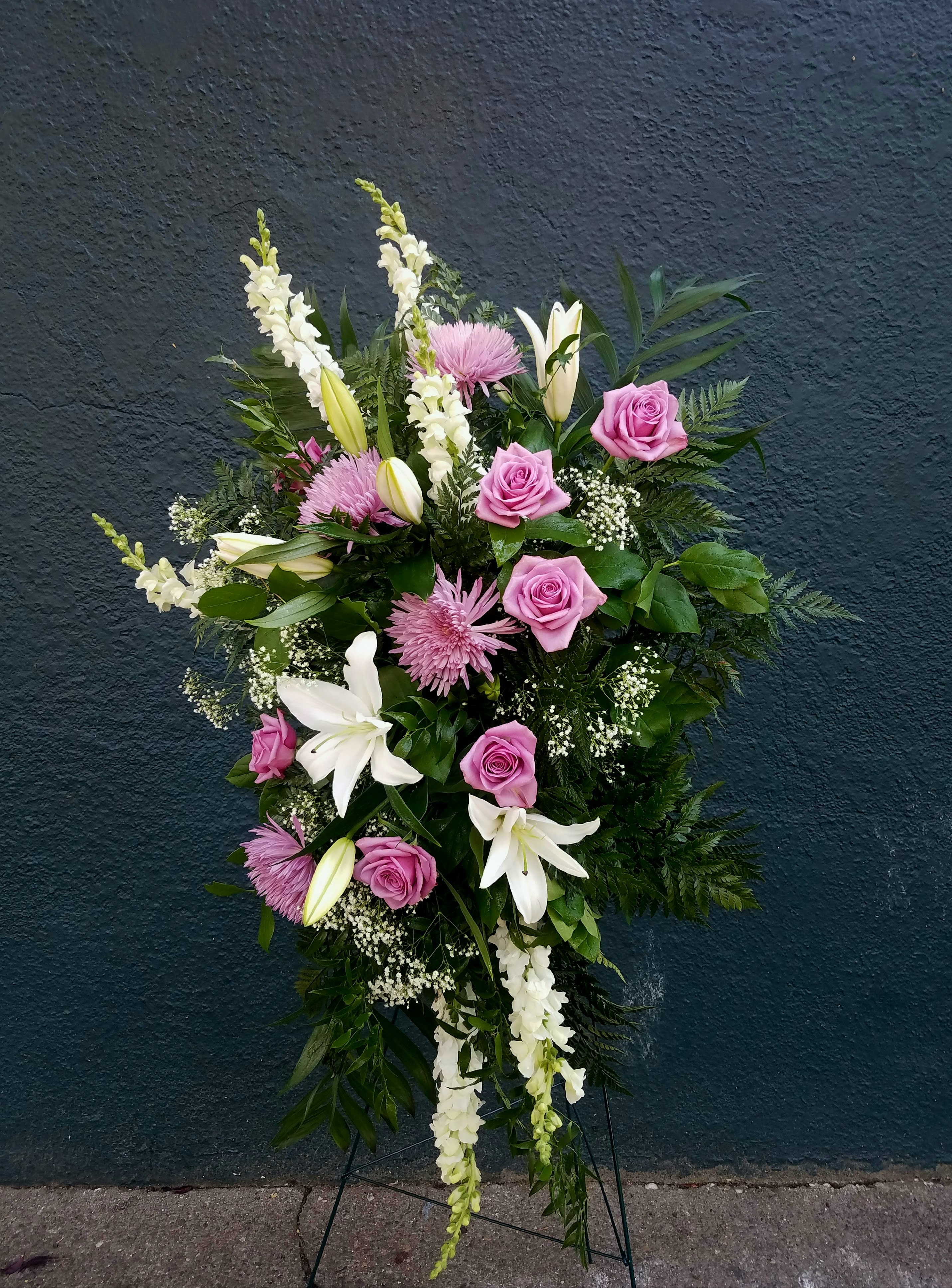 Standing floral spray with pink roses, white lilies, and white snapdragons