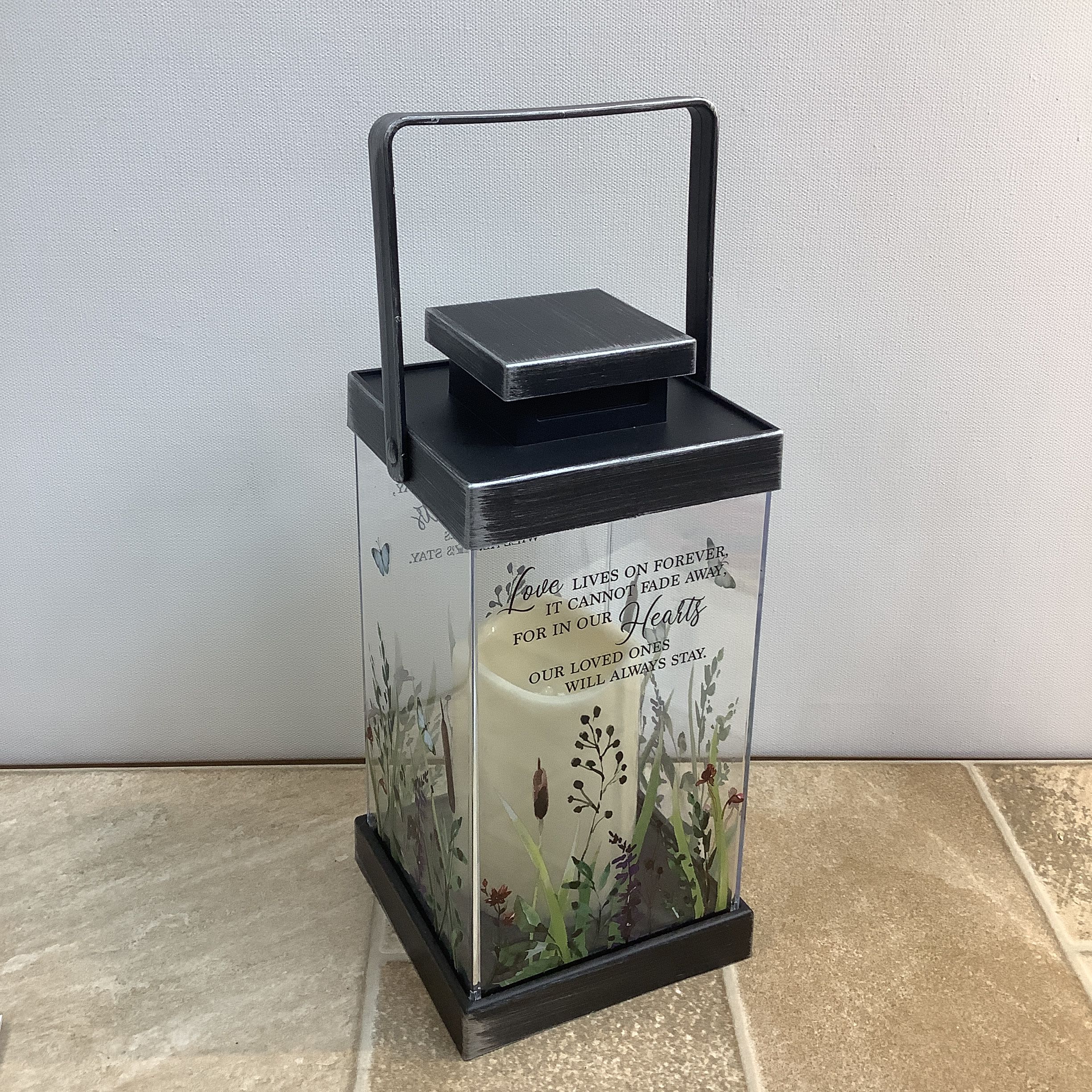 Lantern "Love lives on" - A beautiful memorial lantern with a led candle encased within. It features an all around floral motif with the verse “Love lives on forever, it cannot fade away, for in our hearts our loved ones will always stay.” It measures 5” x 5” x 13” tall. 
