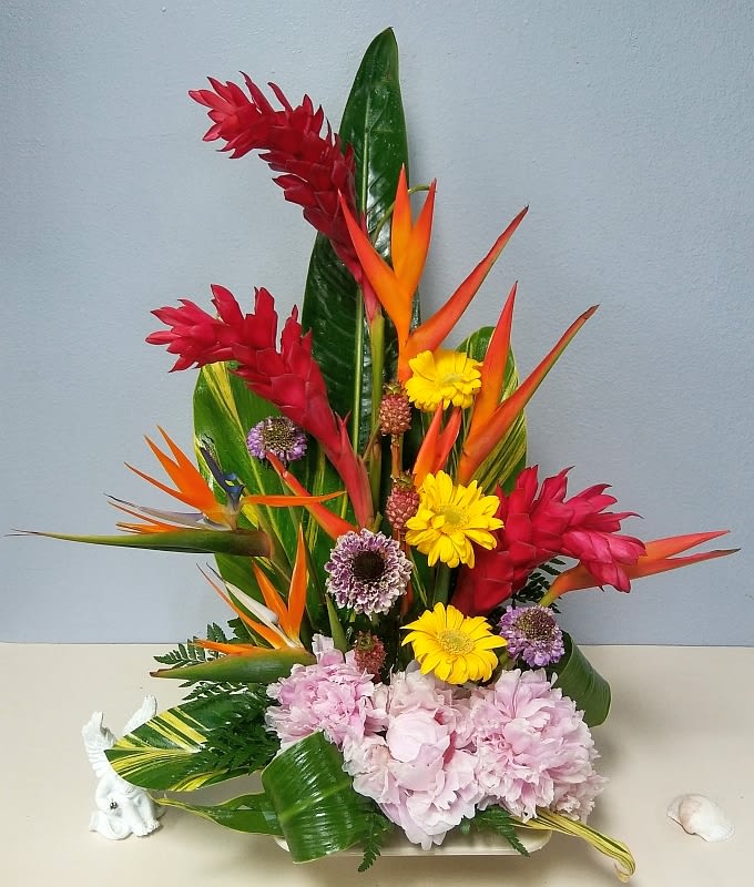 Tropical flower arrangement with red ginger, bird of paradise, yellow daisies, and pink hydrangeas