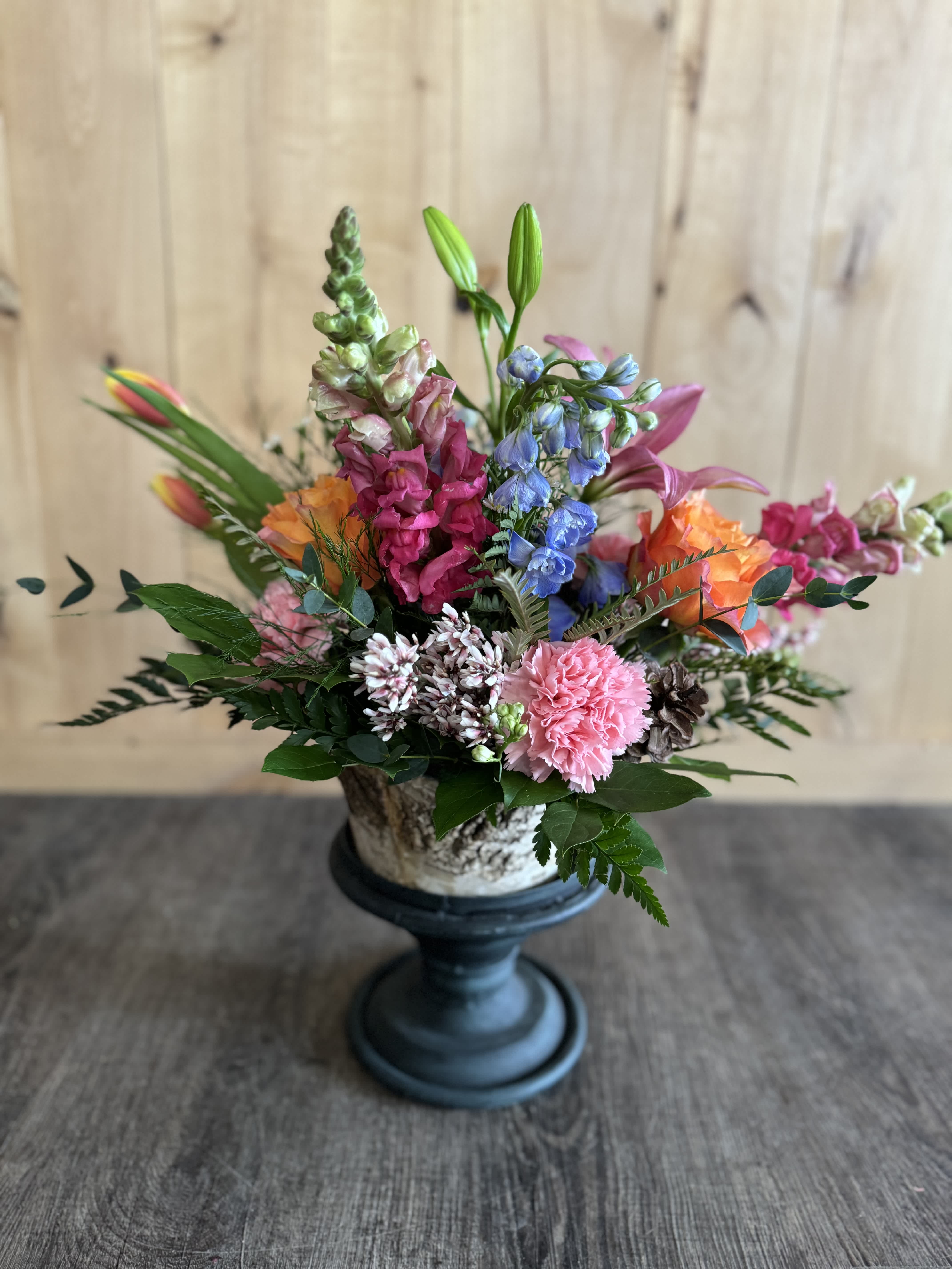 Colorful mixed flower arrangement in a pedestal vase