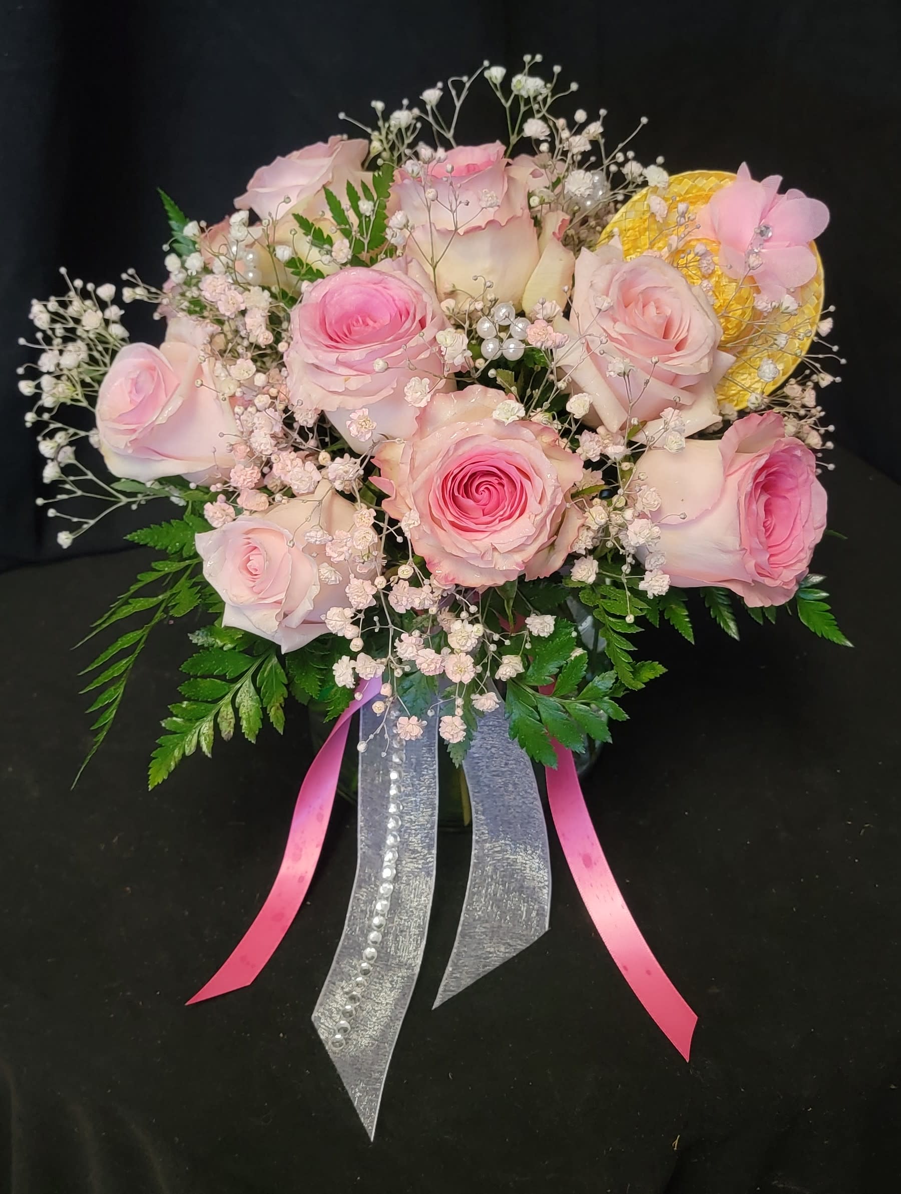 Pink roses with baby's breath and ribbon accents in a bouquet