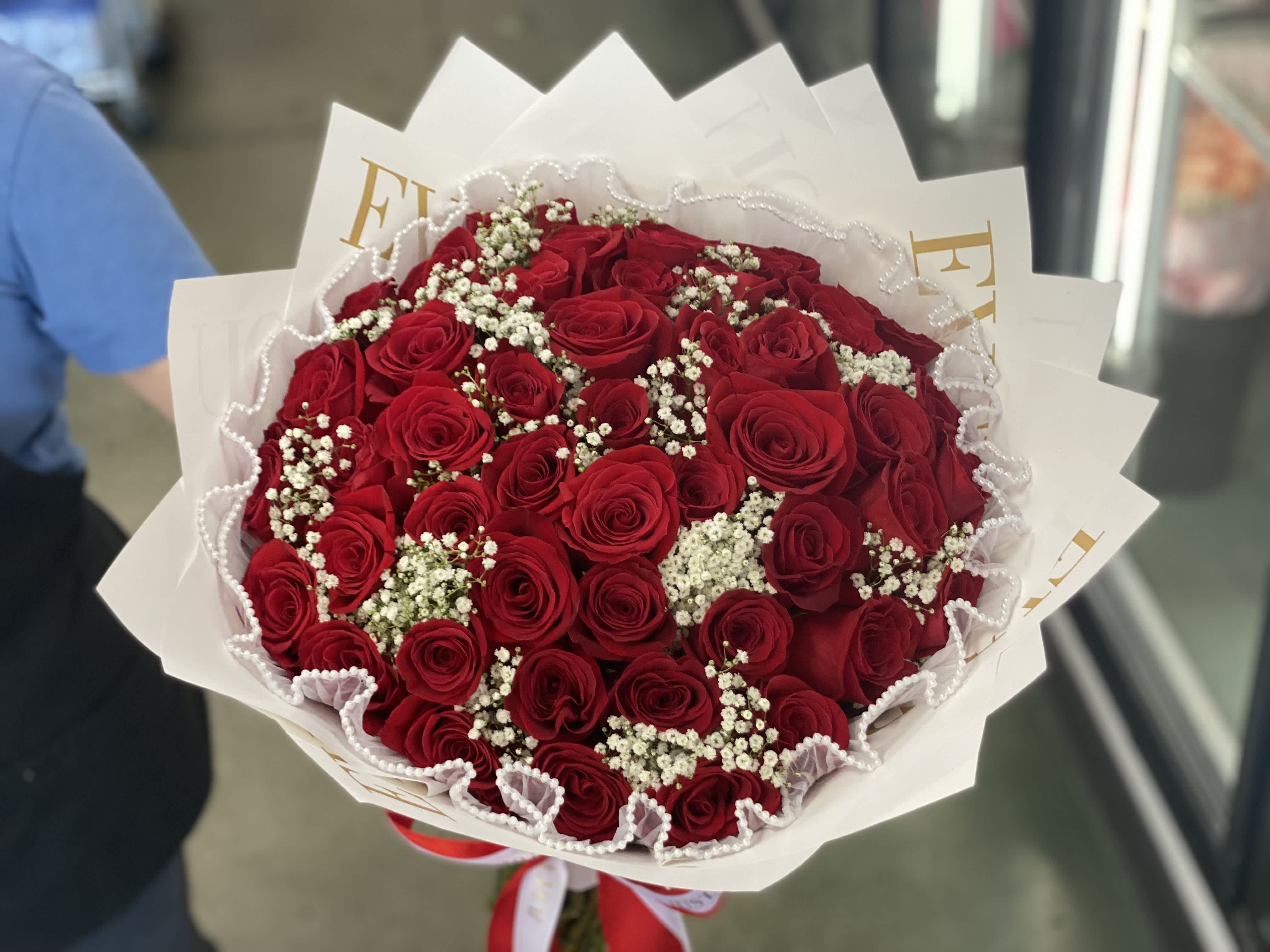 Bouquet of red roses with white baby's breath in white wrapping
