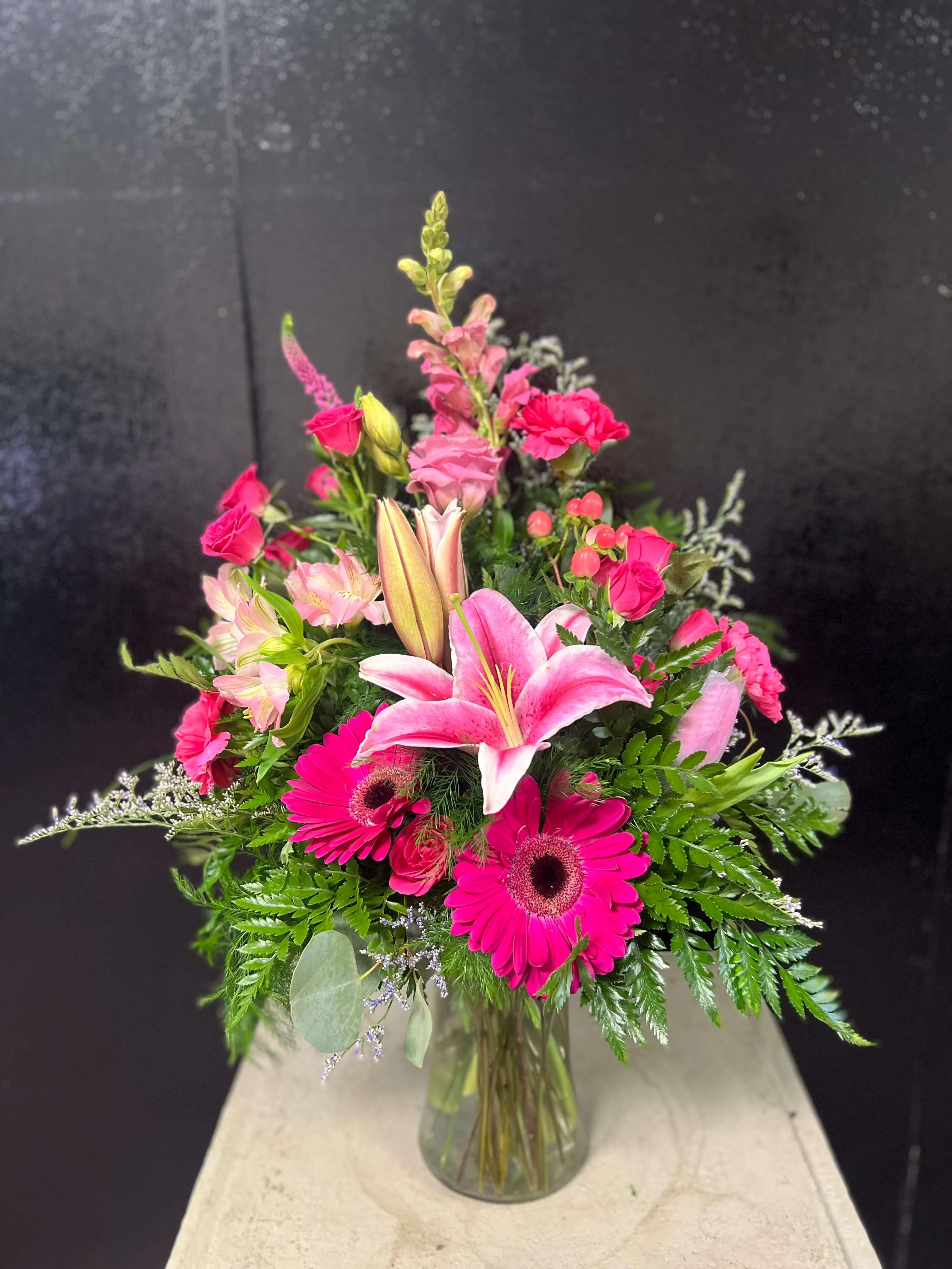 Pink lilies and gerbera daisies in a glass vase