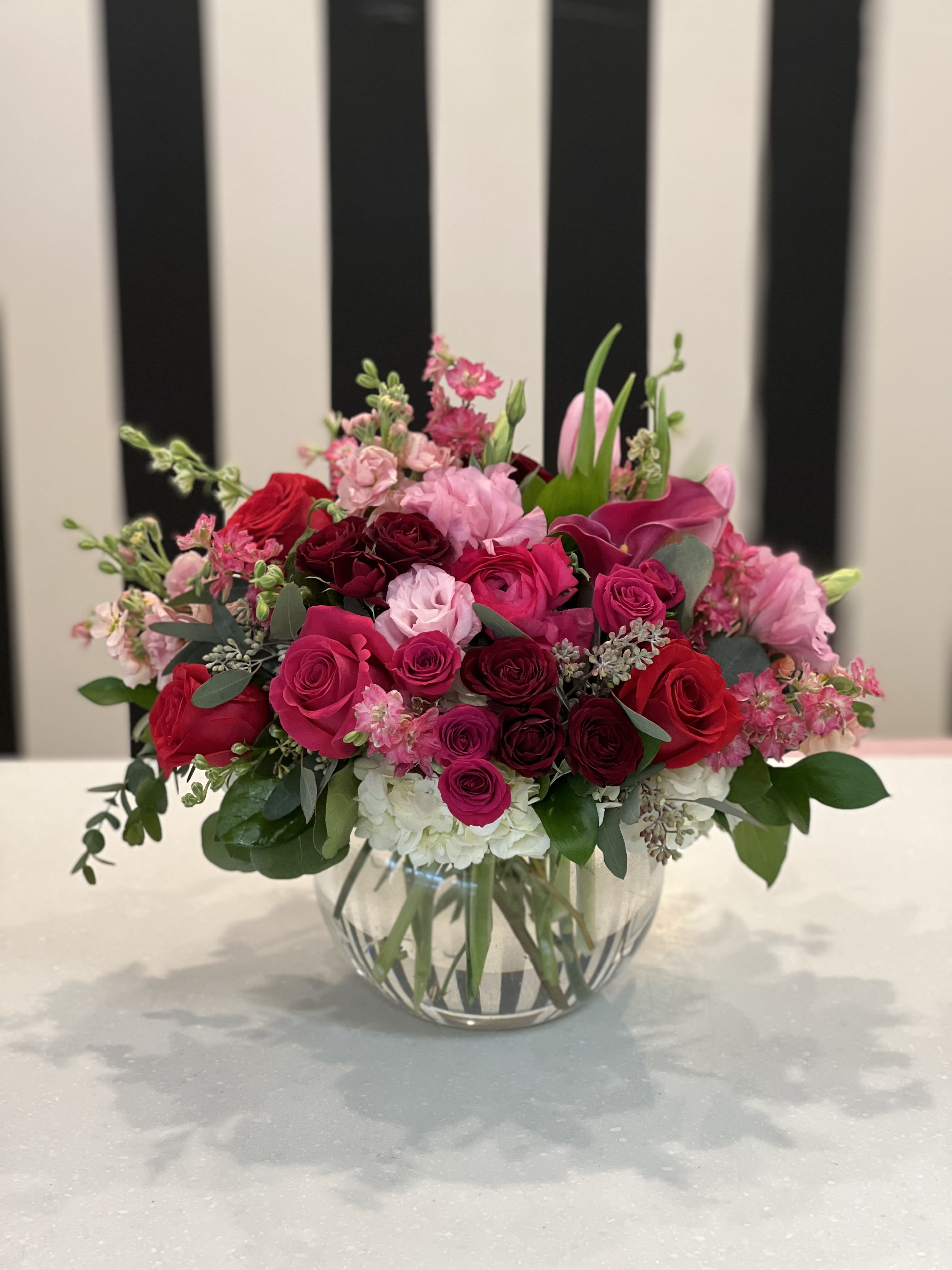 Pink and red rose arrangement in a clear glass vase